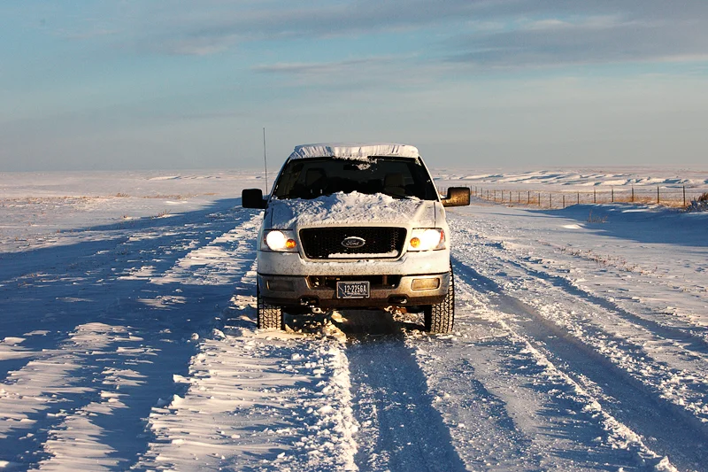 My cold Ford pick-up truck on snow covered road somewhere deep in the Montana hinterland. Here, south of Cleveland, Montana, I was many, many miles from another person. Just another day in paradise. → License Photo