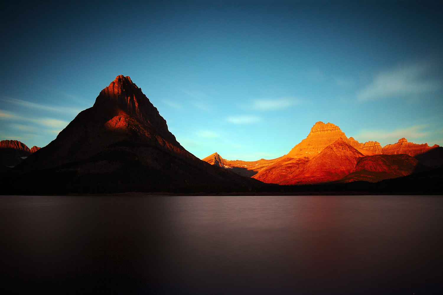 The sun rising over Mount Grinnell and the Rocky Mountains at Glacier National Park.&nbsp; &nbsp;→ Buy This Print