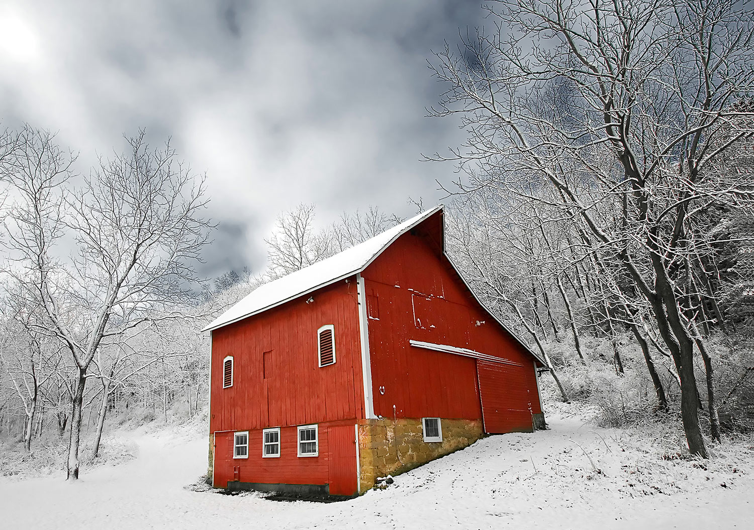 Freshly fallen snow clings to a little red barn on a small farm in the trees.&nbsp;→ Buy a Print
