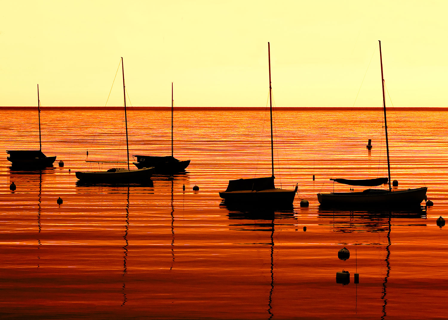 The morning sun casts an orange hue over Rockport Harbor in Rockport, Massachusetts.&nbsp;→ Buy a Print