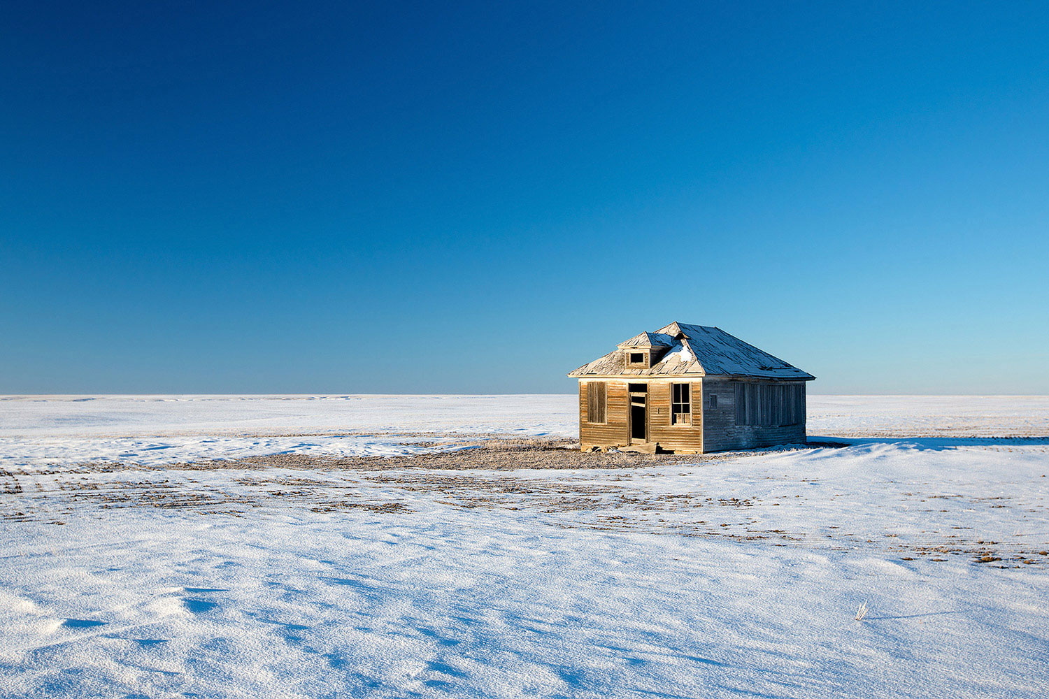 An old, broken-down house surrounded by the vastness of Montana's eastern plains.&nbsp;→ Buy a Print