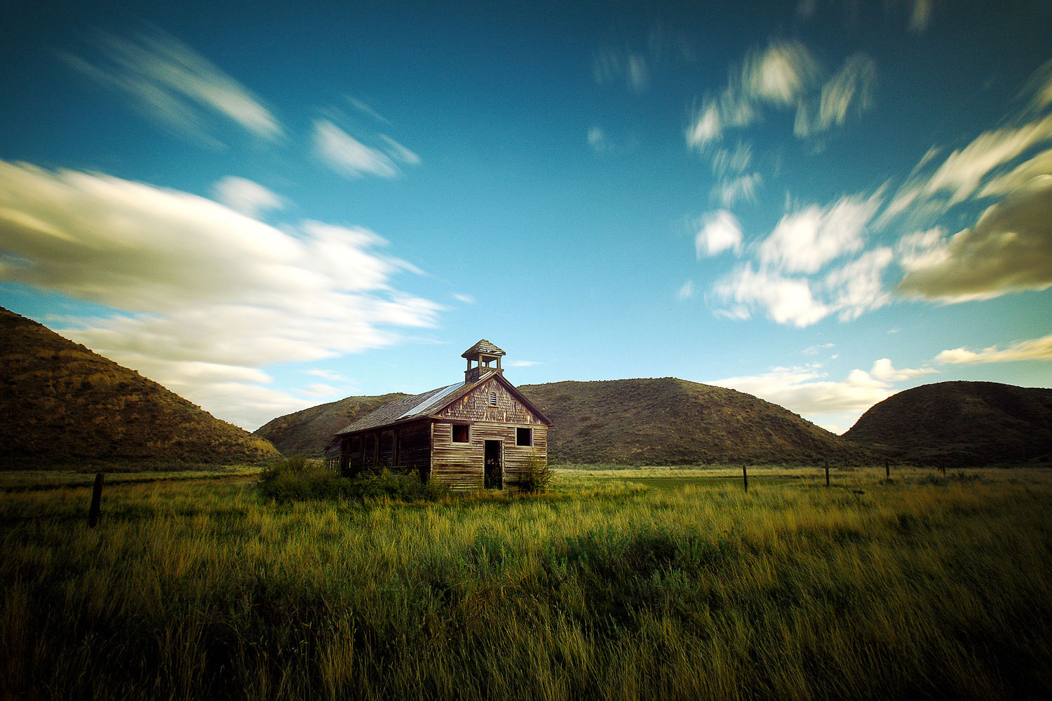 An old, weathered schoolhouse or church tucked between the hills outside of Loma, Montana.&nbsp;→ Buy a Print