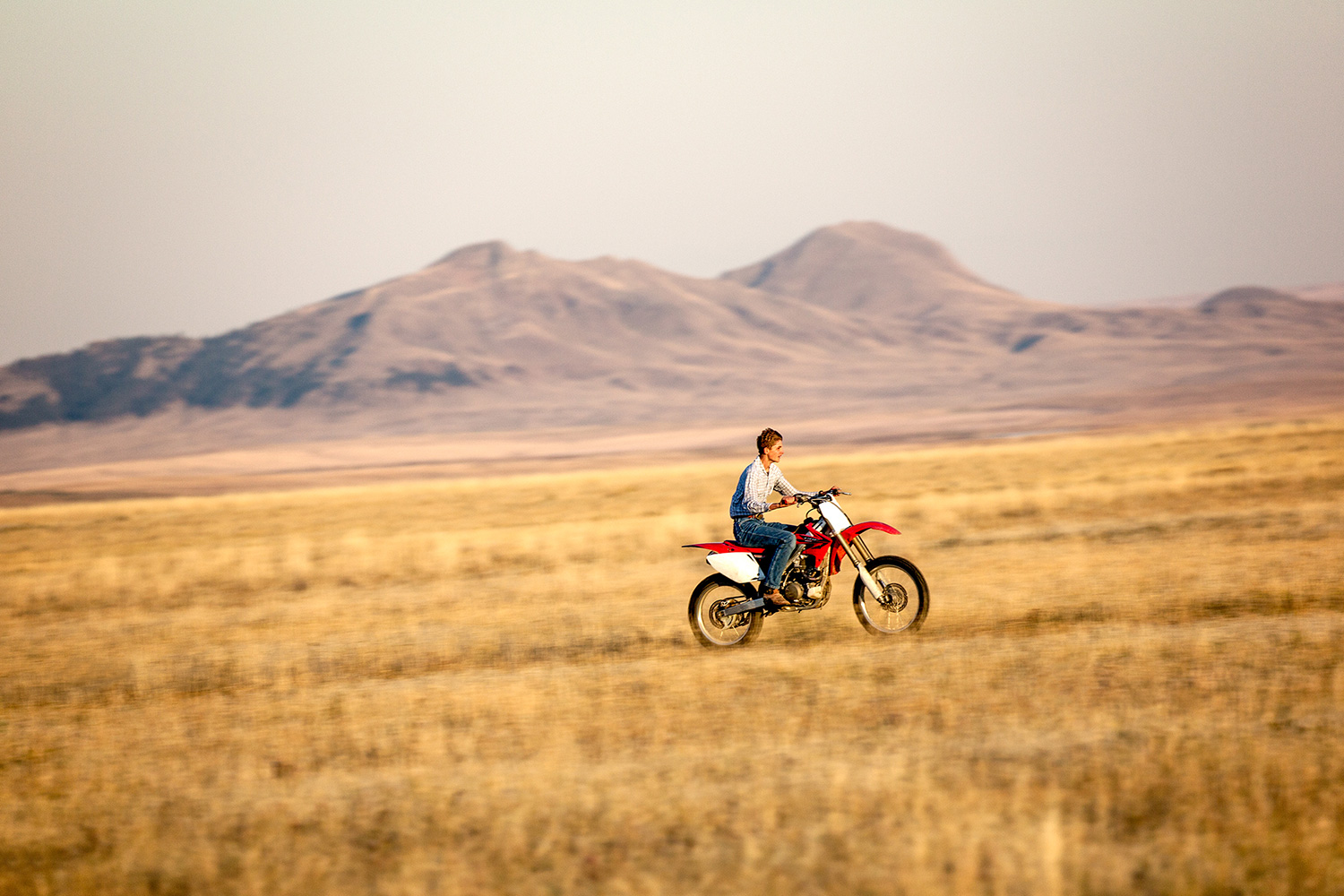 A teen riding his motorcycle fast across the open plains near Cleveland, Montana.&nbsp;→ License Photo