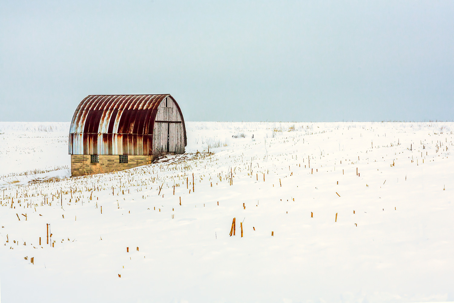 An old barn with a red, rusty roof stands alone and abandoned on a snowy landscape outside of Monroe, Wisconsin.&nbsp;→ Buy a Print