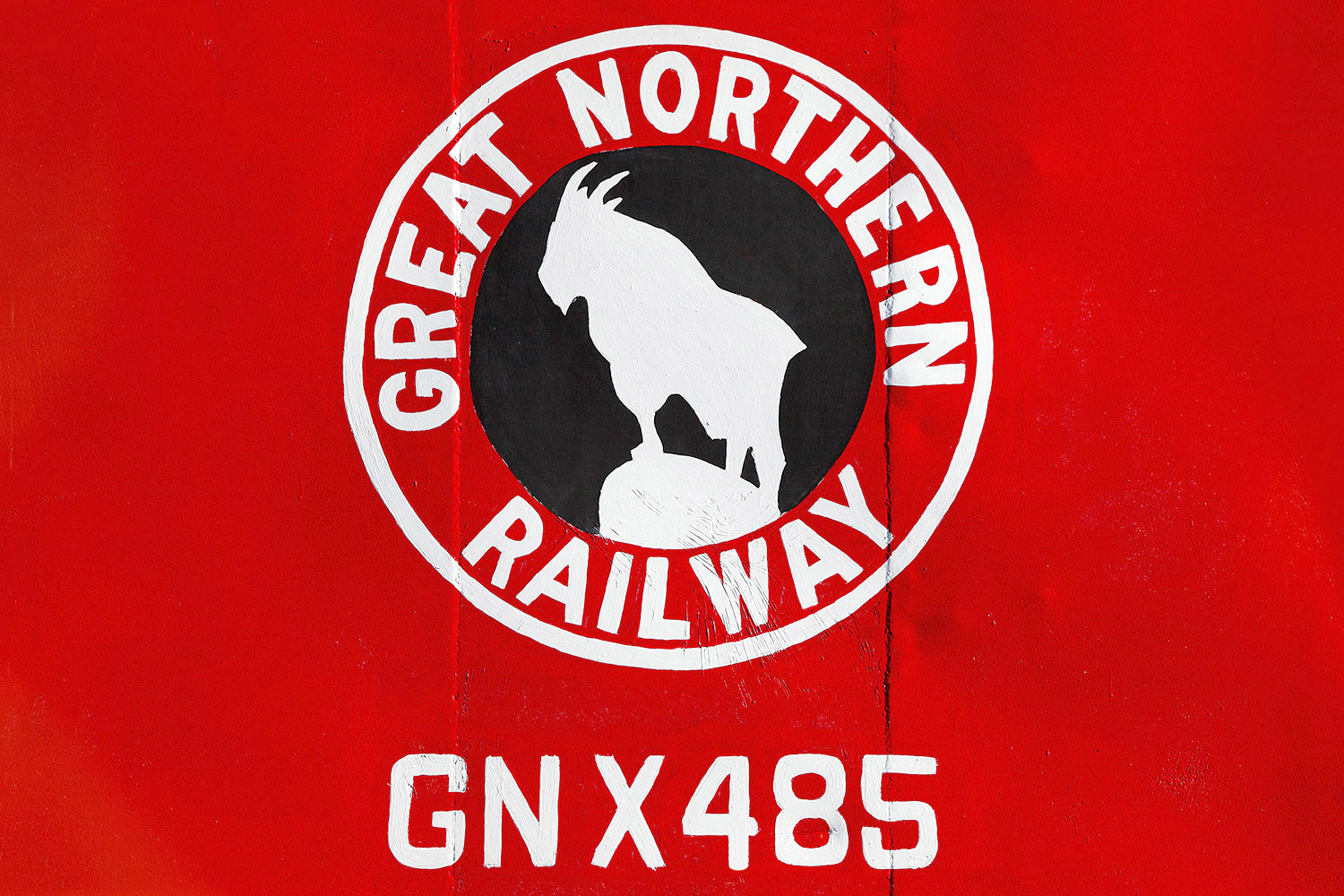 A close-up of the Great Northern Railway logo on the side of a caboose in Havre, Montana which is painted in bright, bright red.&nbsp;→ Buy a Print&nbsp;or&nbsp;License Photo