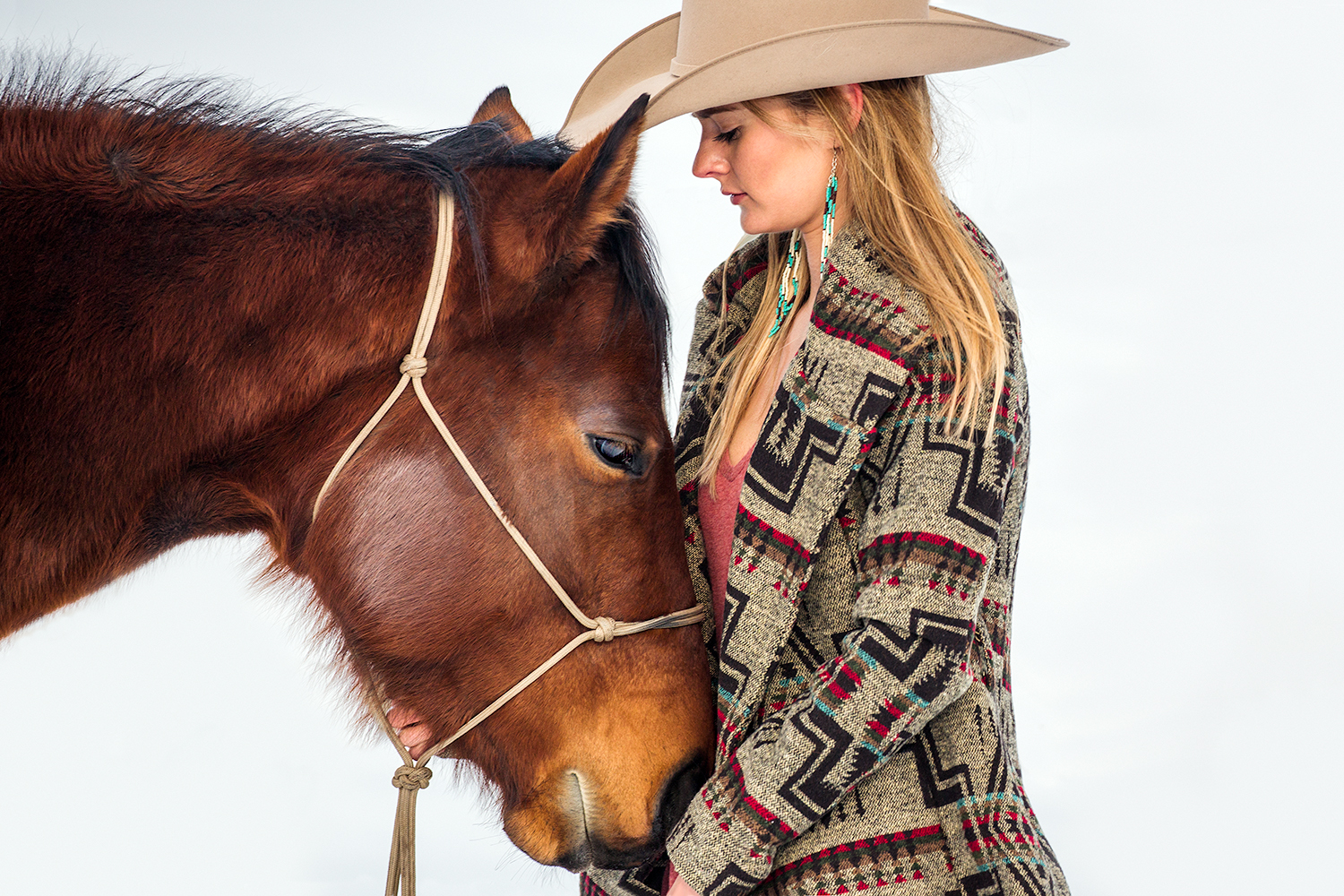 A cowgirl rubs the chin of her horse on a ranch outside of Bozeman, Montana.&nbsp;→ License Photo
