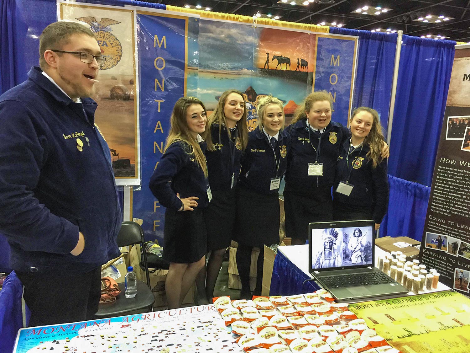 Members of the Montana FFA delegation pose in front of my photos at their booth at the National FFA Convention in Indianapolis, Indiana.