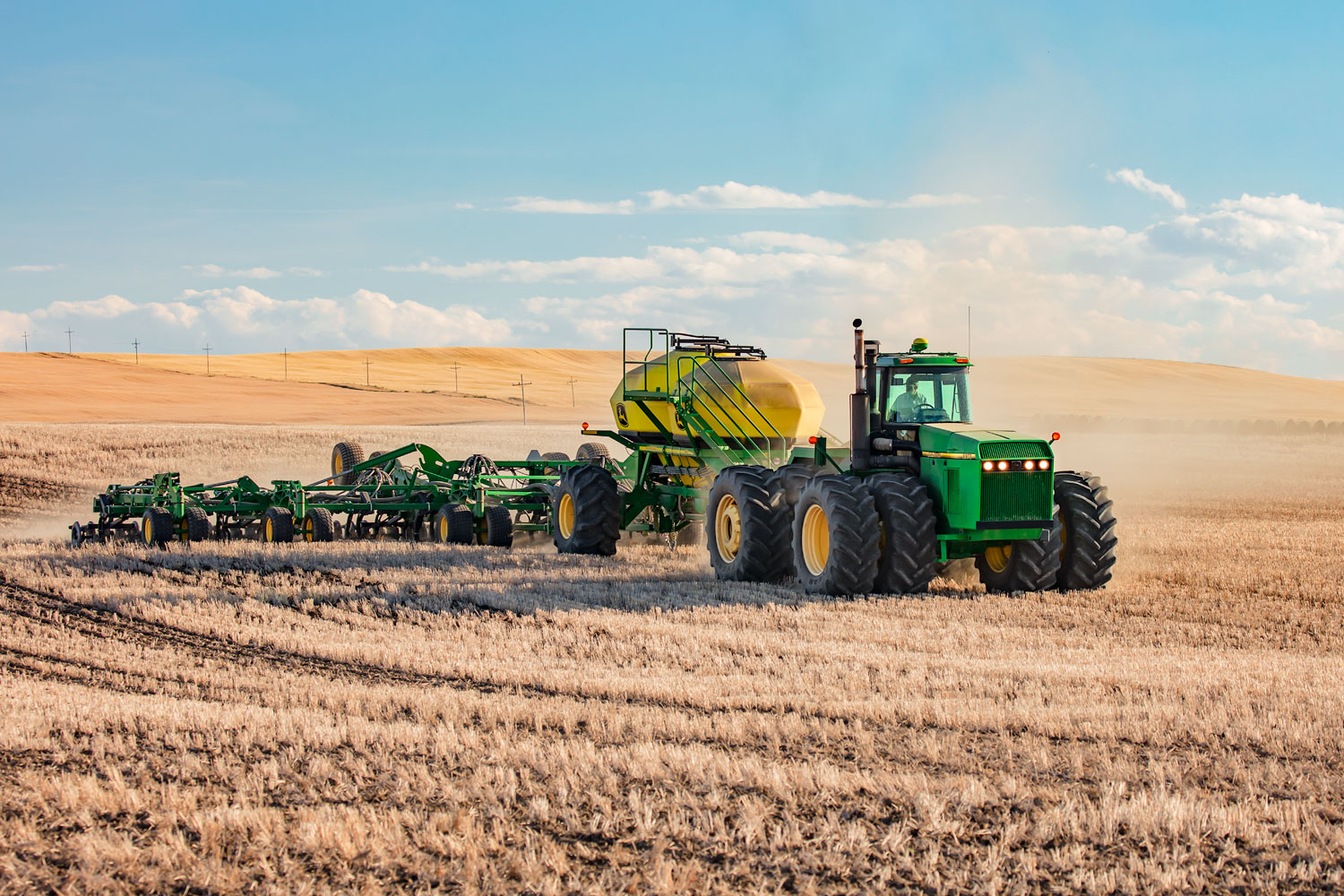A John Deere 8970 tractor pulling an air drill while seeding wheat near Conrad, Montana.&nbsp;→ License Photo