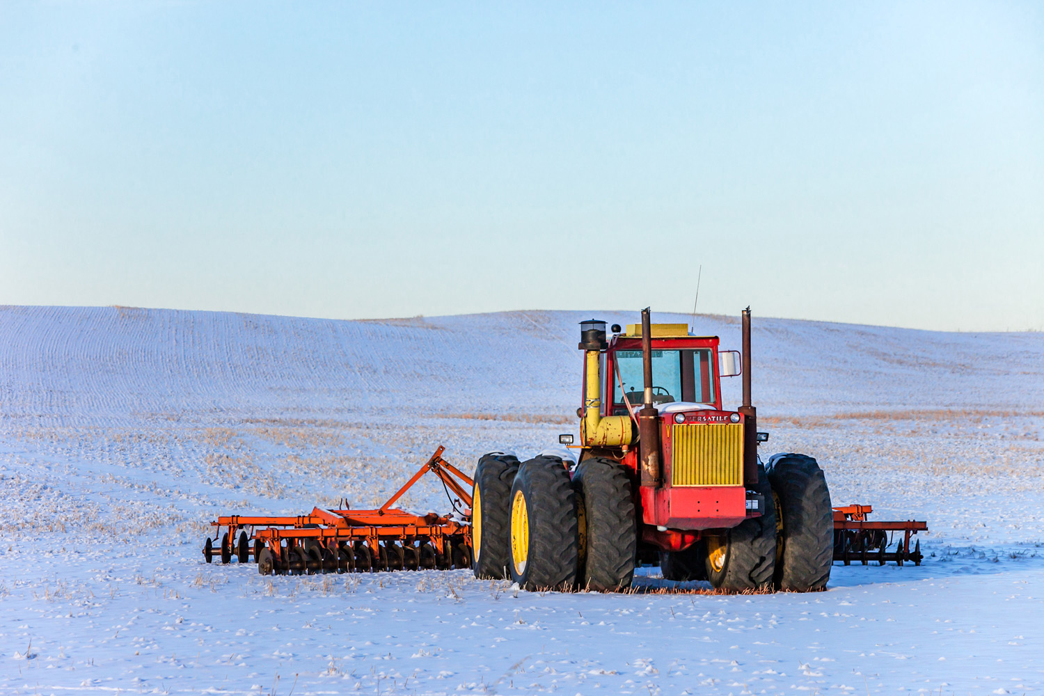 An old Versatile 900 tractor stands out in a field of snow near Fort Benton, Montana.&nbsp;→ License Photo
