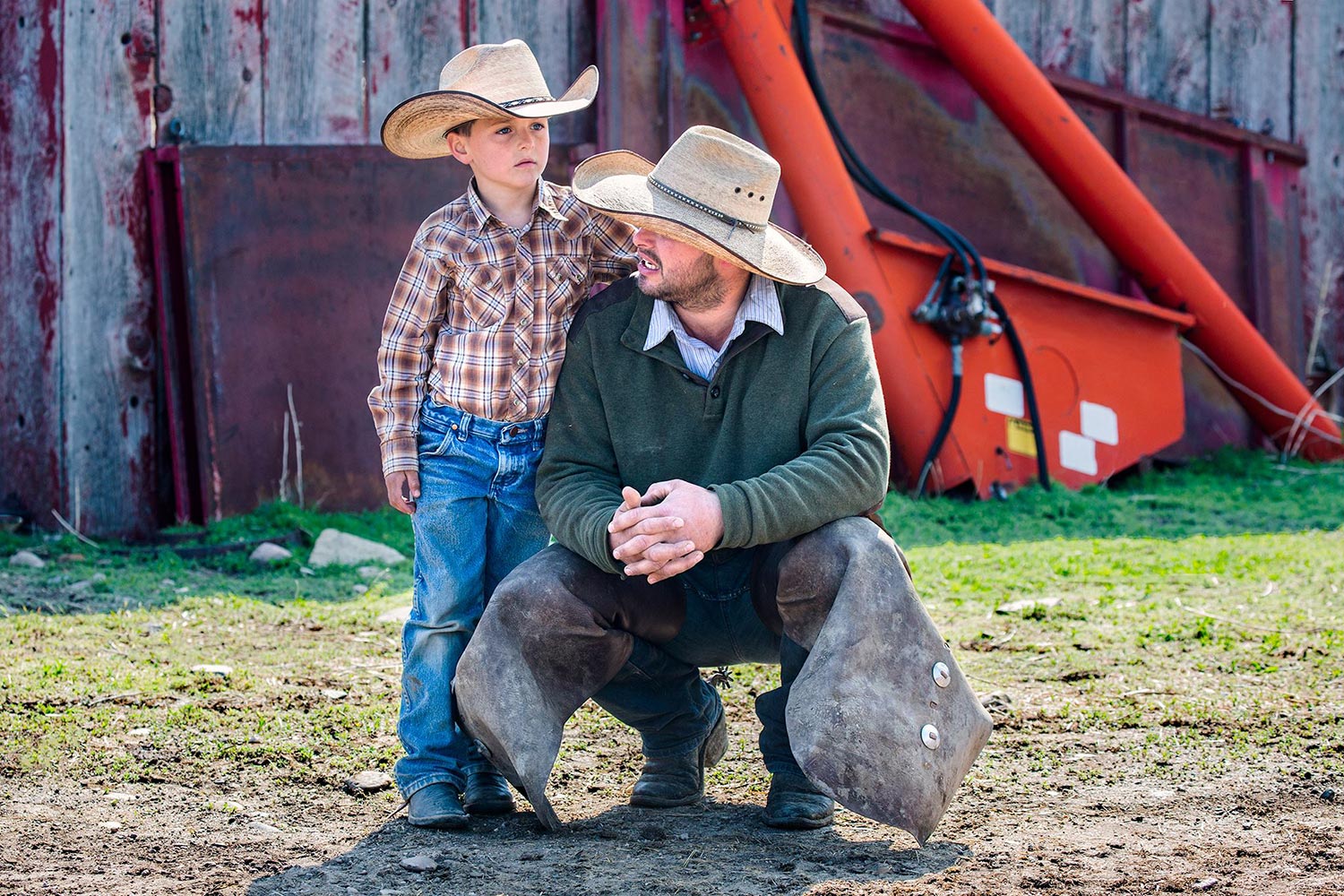 Ethan Klingman and his father Larry take a break in the action on branding day on the Gordon Cattle Company ranch near Chinook. → License Photo