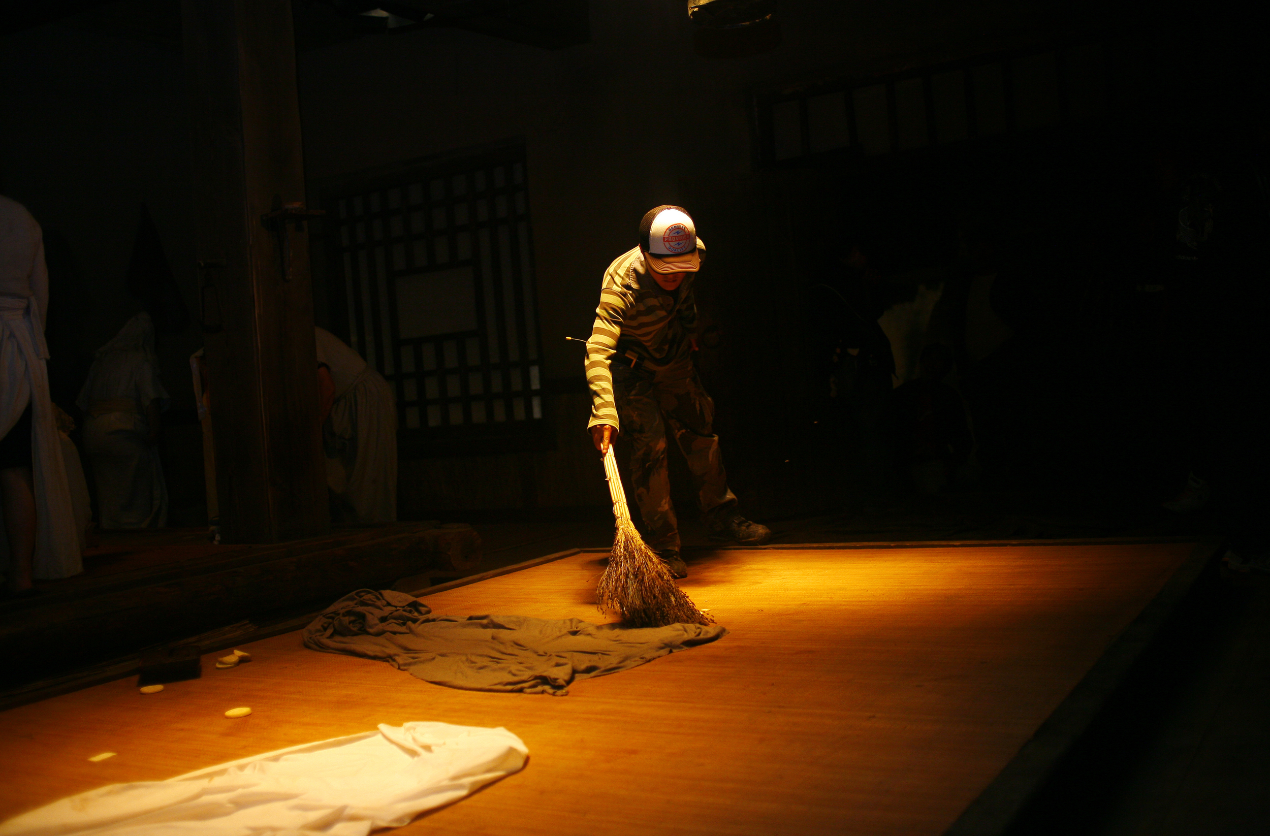 A crew member cleans up the set between takes.