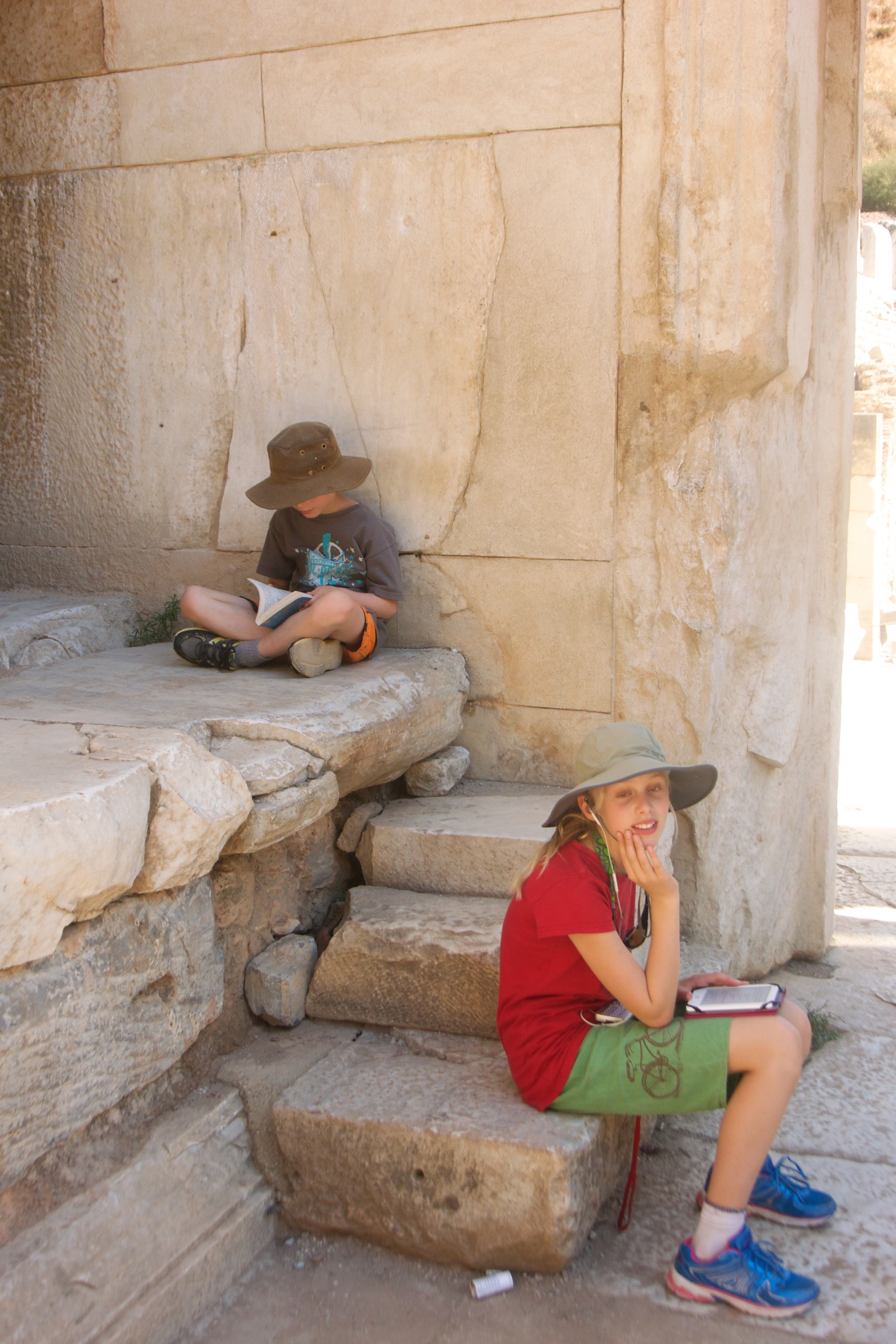 Zoe reading on her Kobo and Isaac reading "Diary of a Wimpy Kid" in the Celsus Library. 