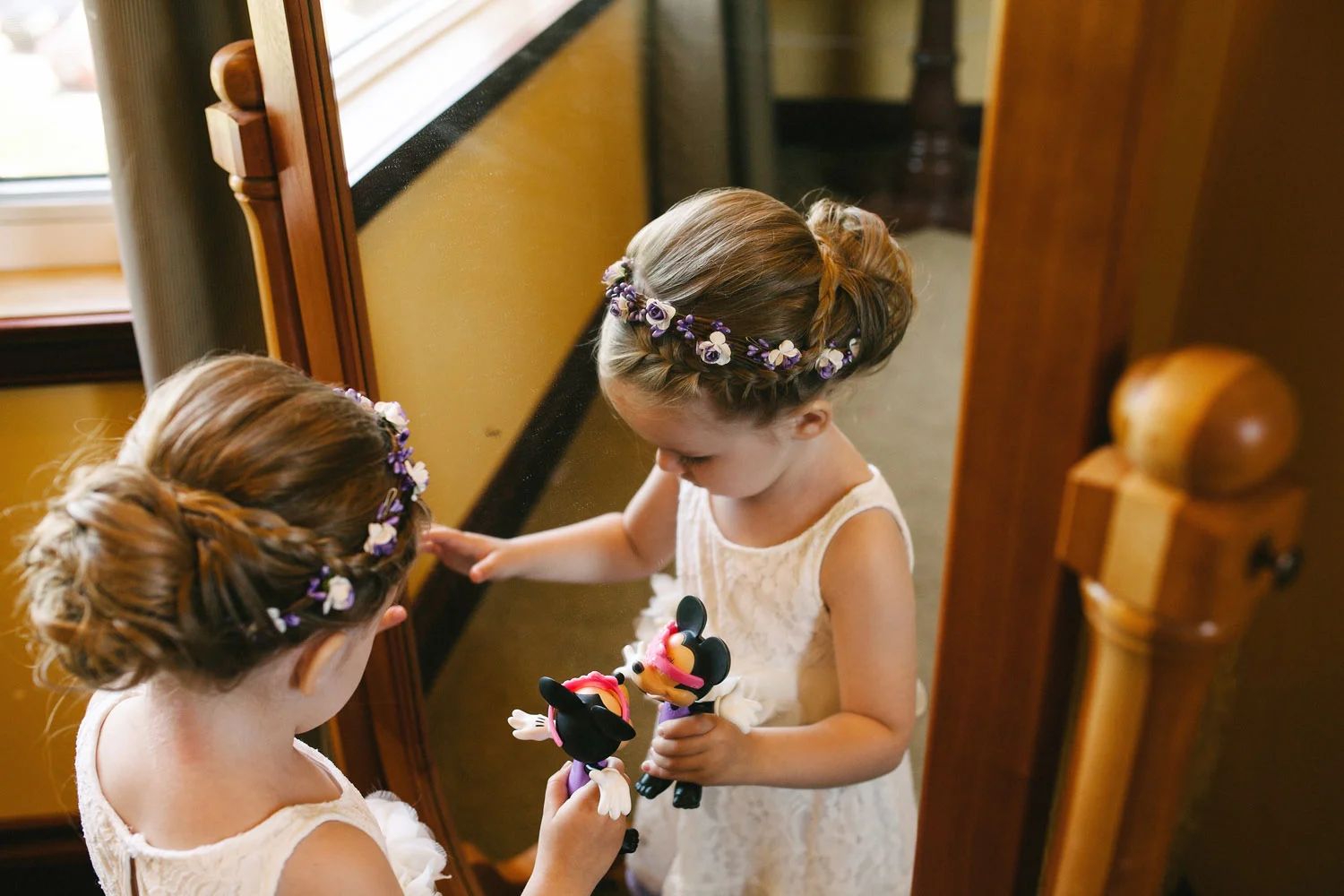 Flower girl plays with mirror and toys