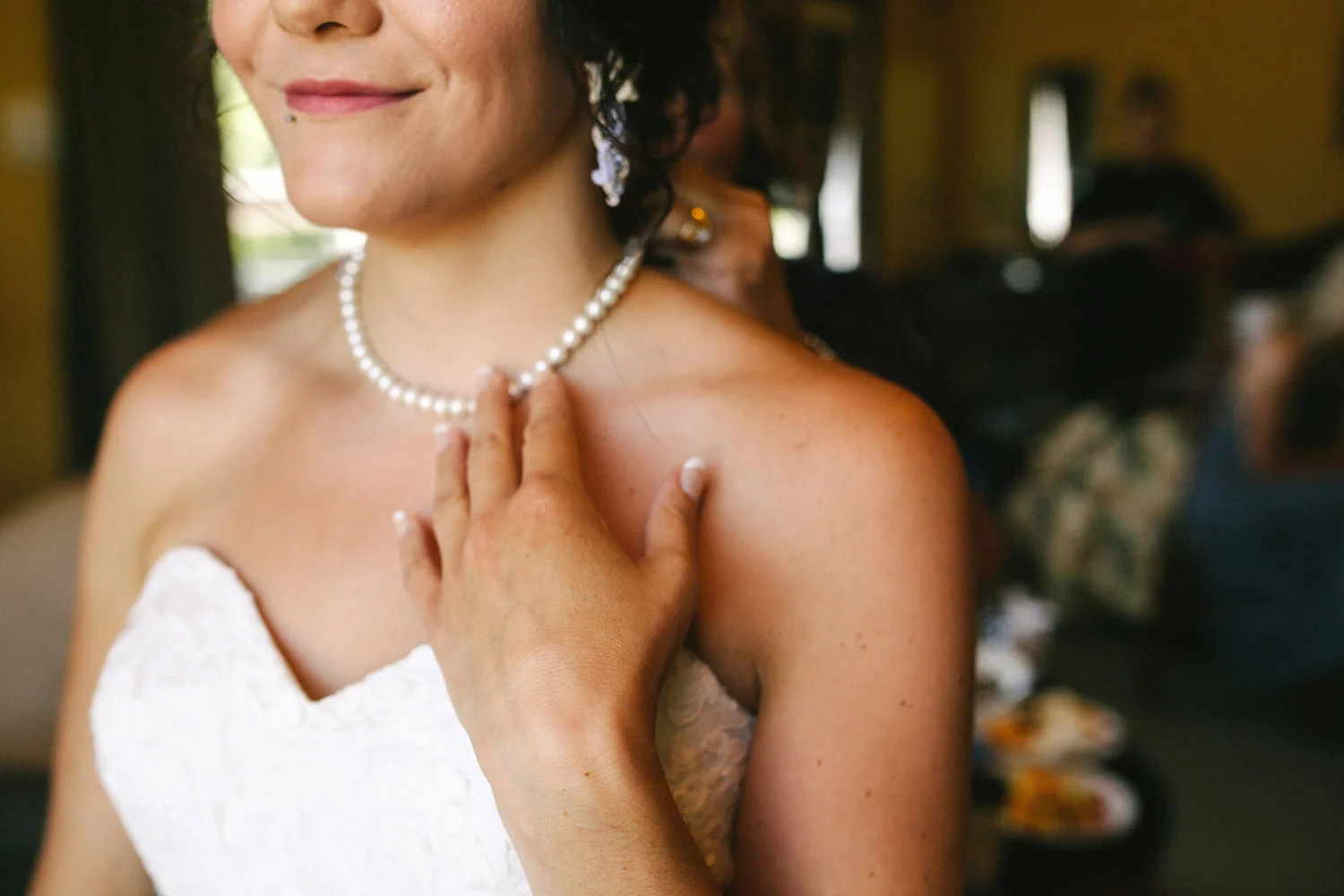 Bride touches her Grandmother's pearls