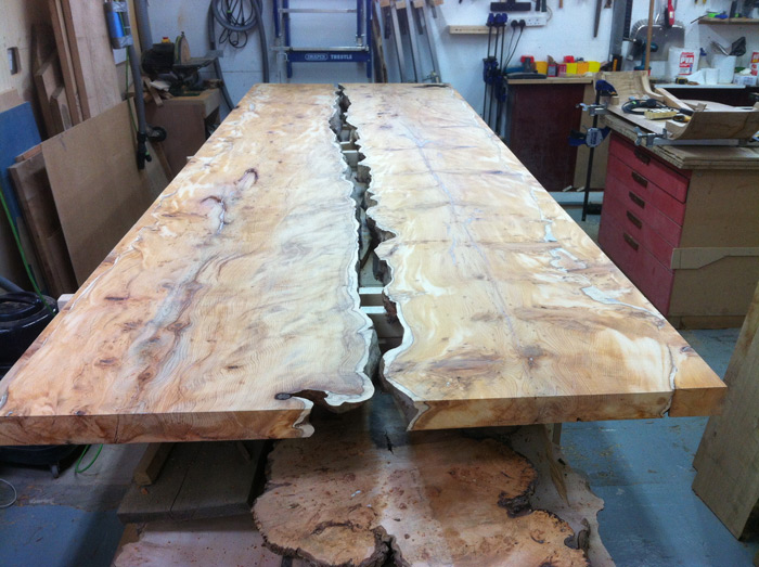 The positioned outer side of each piece of yew is made wider by adding along the waney edge with further yew, then cut straight for the table side edges and sanded before the first of three oilings.