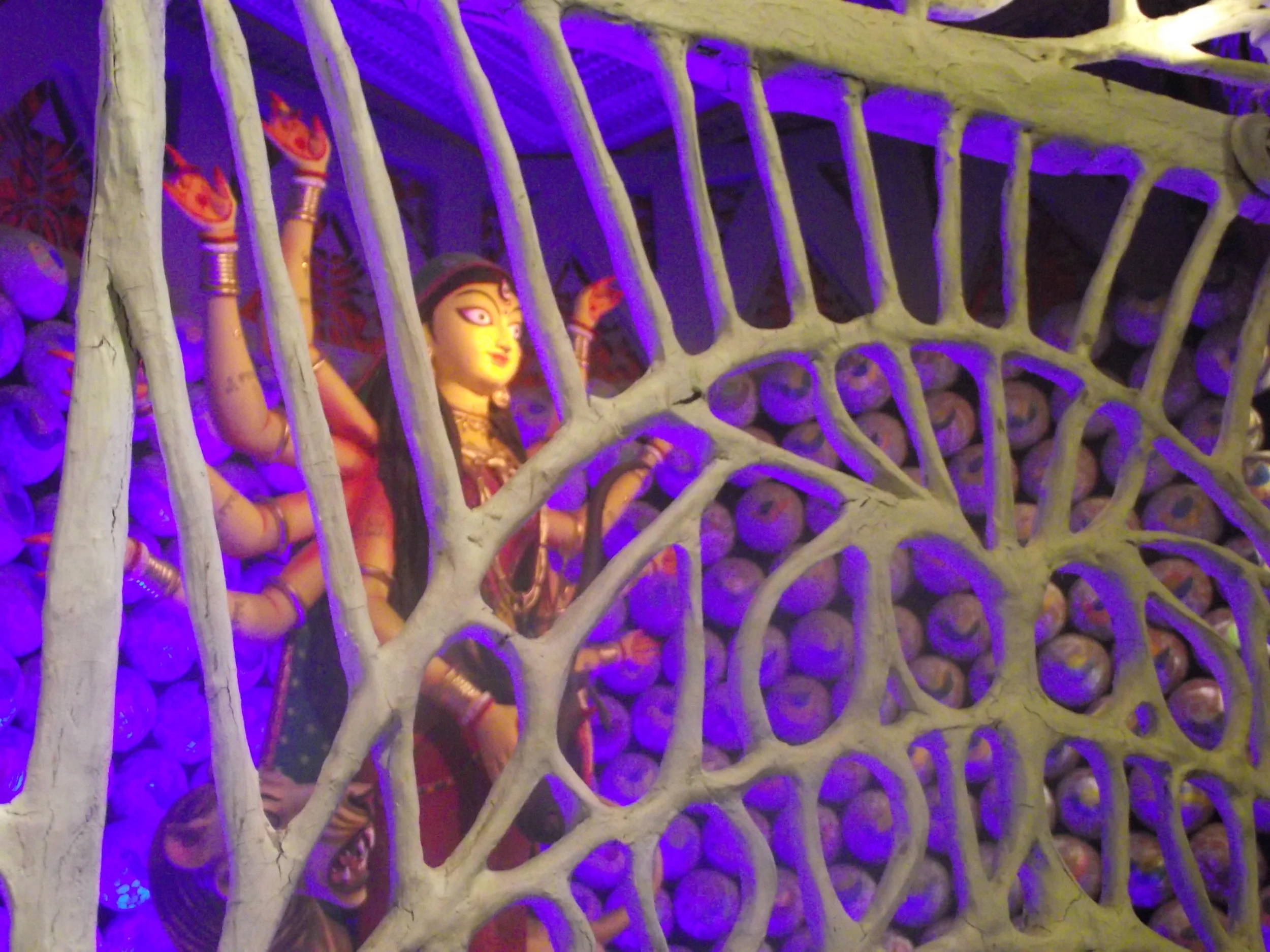  The pandal had a mix of Warli, Phad and Gond styles intermixed with each other. Here is an innovative shot where you can catch a glimse of Durga through the artistic mesh... 