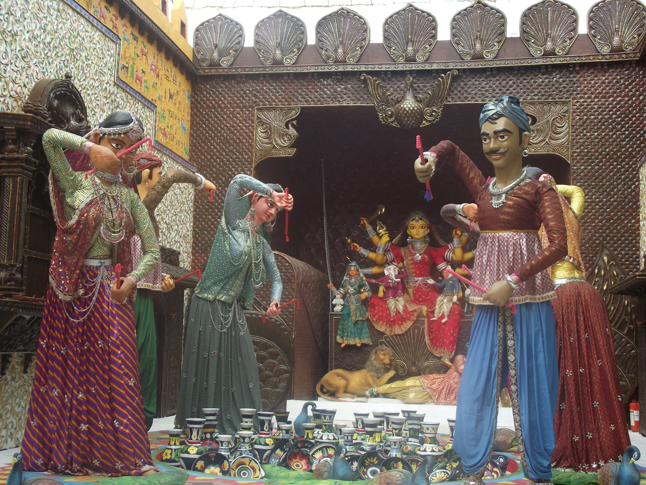  People in a celebratory dandiya mode in the palace courtyard. Observe the miniature works created on the walls. 