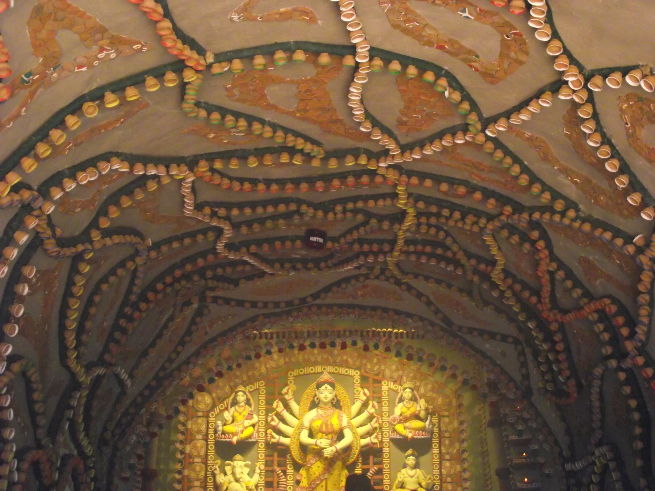  As one enters the main centrestage, the ceiling was decorated with small clay pots (matir bhar typically used to have tea in Kolkata tea stalls). All arranged in perfect symmetry and painted with a white border. 