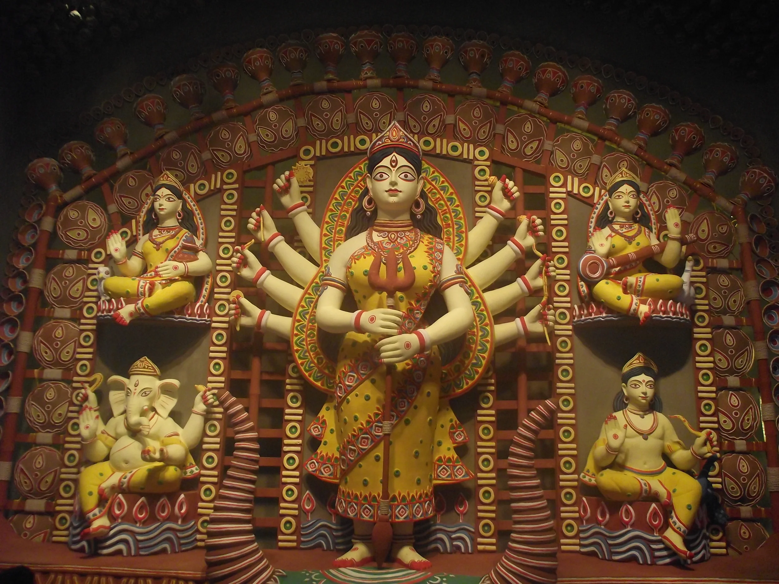  The full frame of the idol. Notice the symmetry in the postures of Laxmi, Saraswati, Ganesha and Karthik. The simplicity of the ornamentation matches with the overall thought of focusing on terracotta / clay modeling 