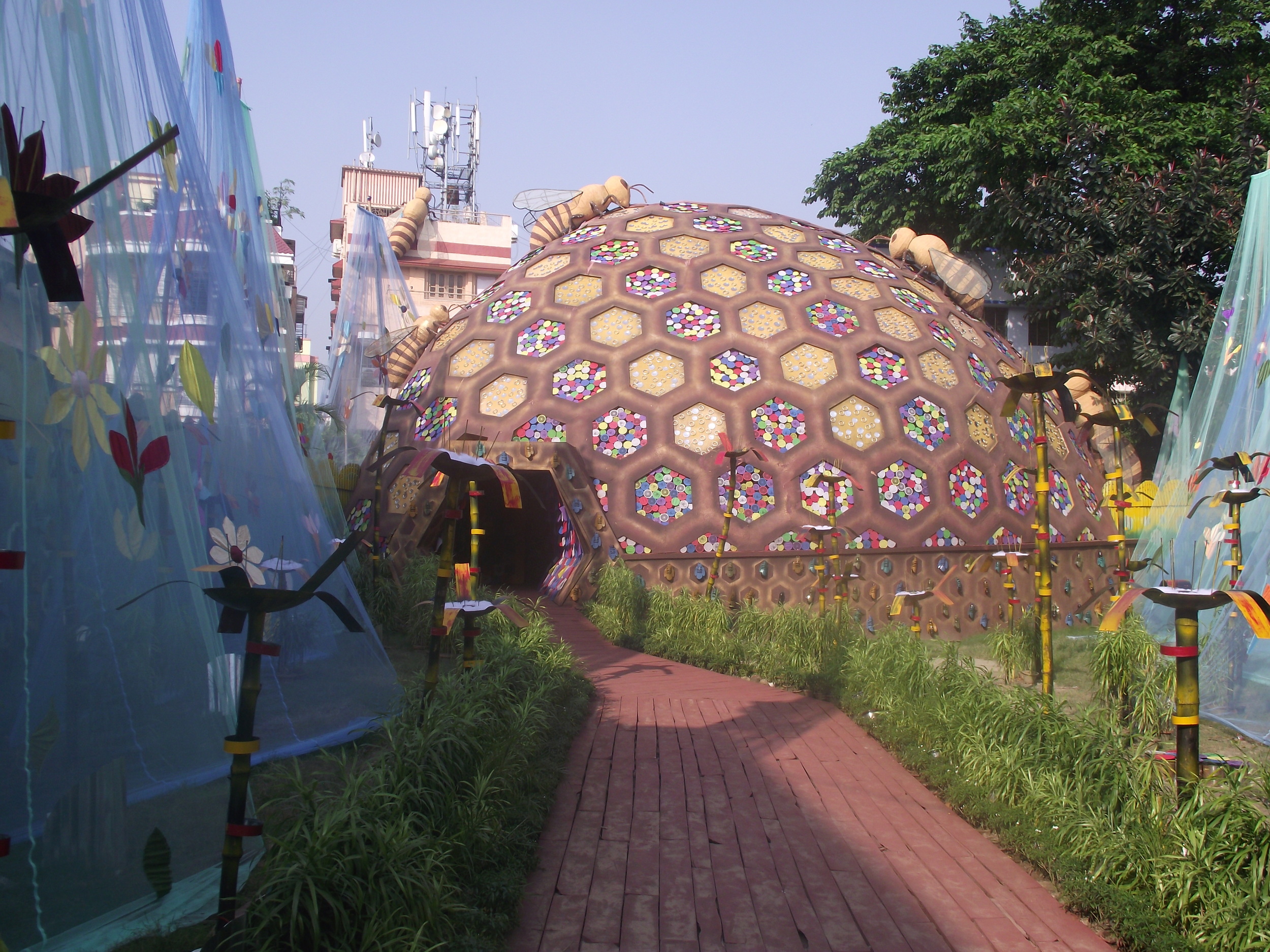  Dome shaped honeycomb like structure with lots of bees storing the nectar. Both sides had a symbolic wave with flowers. 