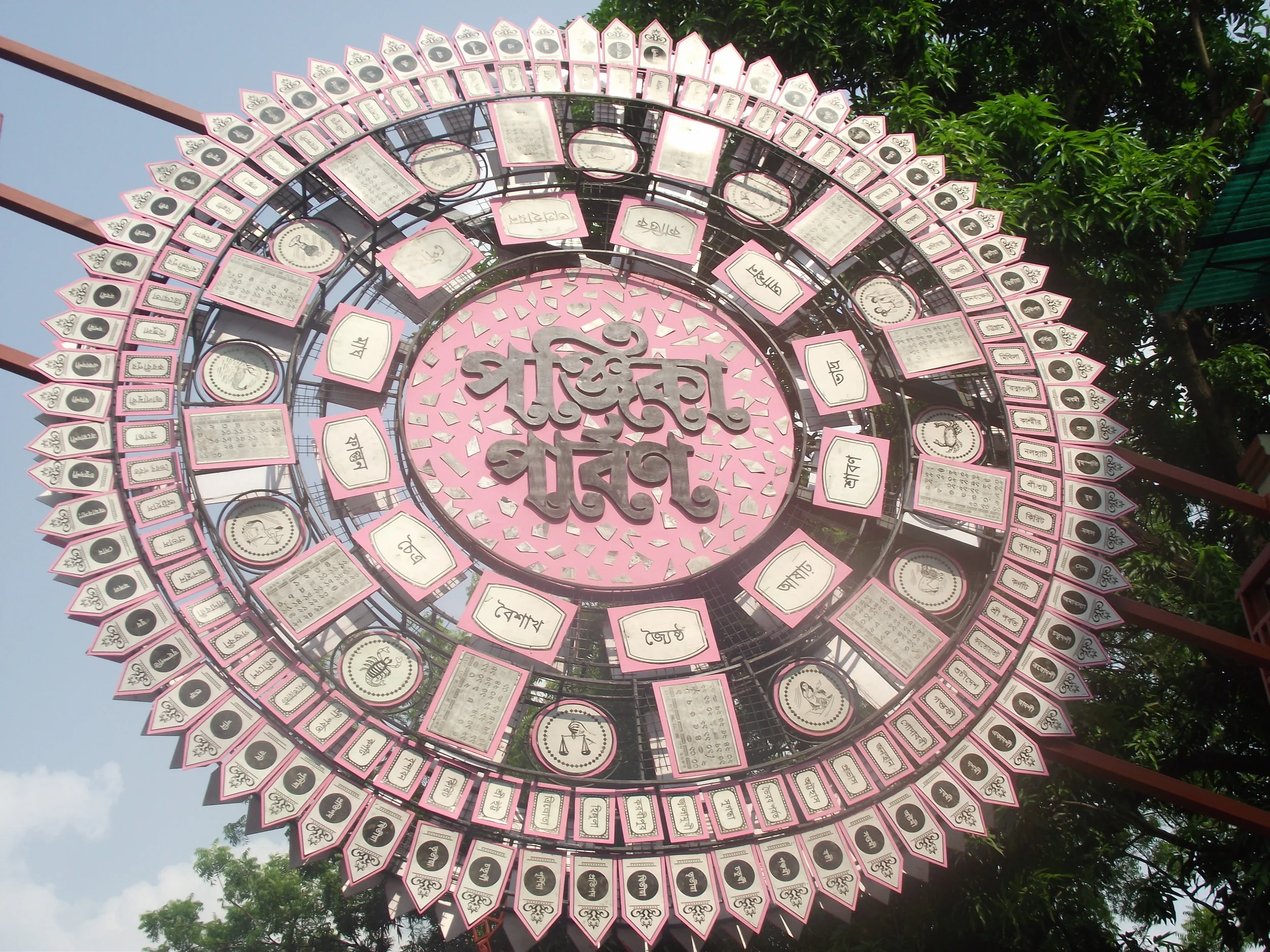  The entrance to the pandal premises. The symbol announced the reliability of Bengalis on the almanac. There is a saying bengalis celebrate "13 festivals in 12 months" ( baro mashe tero parbon ) which essentially means that we have more celebrations 
