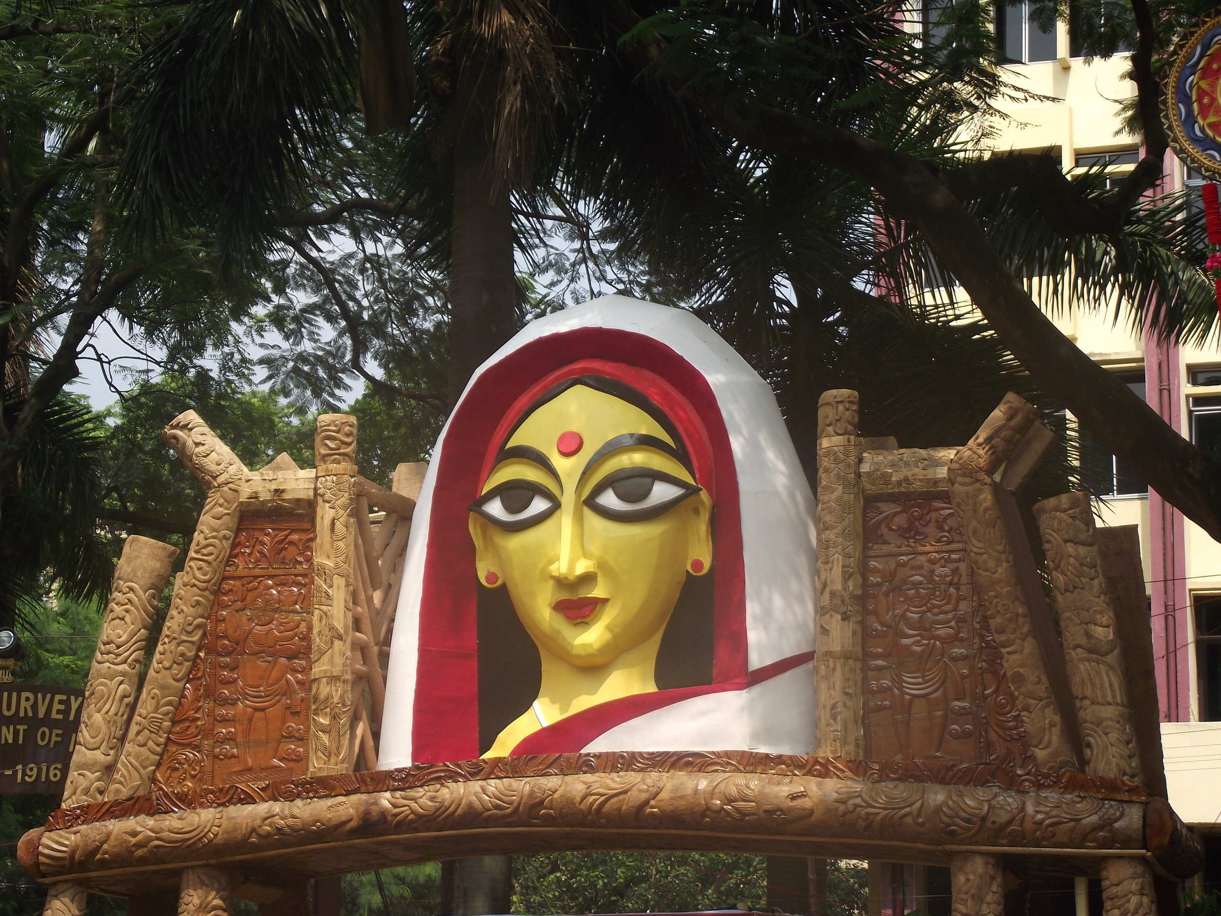  Entrance gate to the pandal of Suruchi Sangha. Observe the fine carving of woods and the symbol of Maa at the epicentre. 