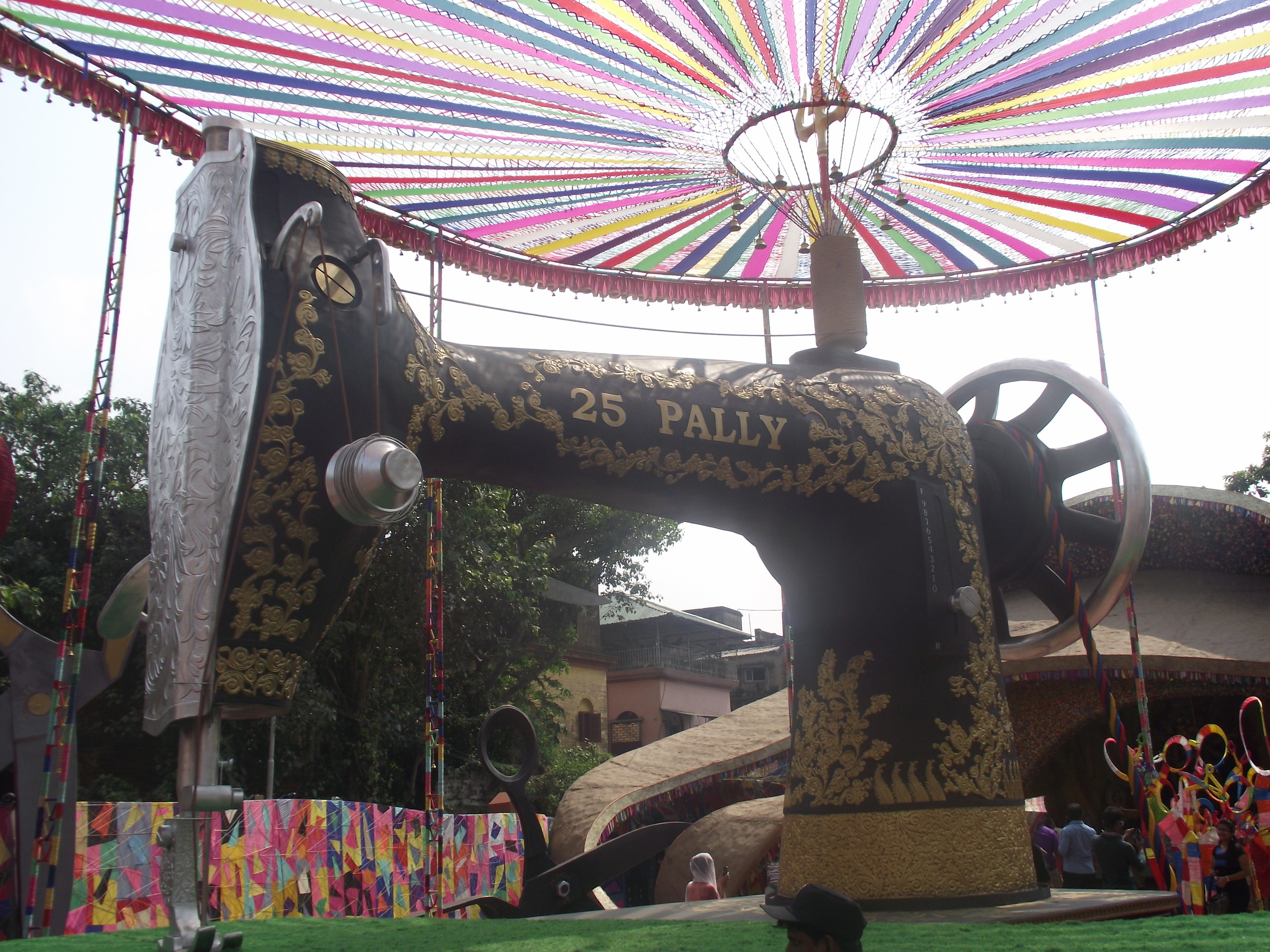  And a symbolic sewing machine was created to state that Maa will continuously stitch back any splits. The use of coulourful threads indicate harmony and diversity in the society. 