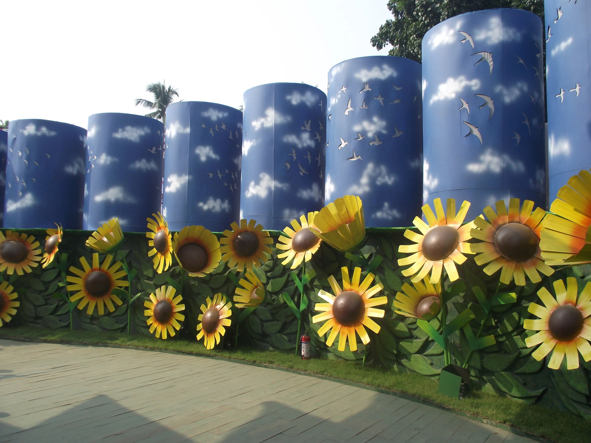  The effect of sky was created with this cylindrical drums and cutouts of flying birds on them. The effect of this light in the evening was looking absolutely magical. And in the sunlight are blooming the bright sunflowers. (Note the sunflowers were 