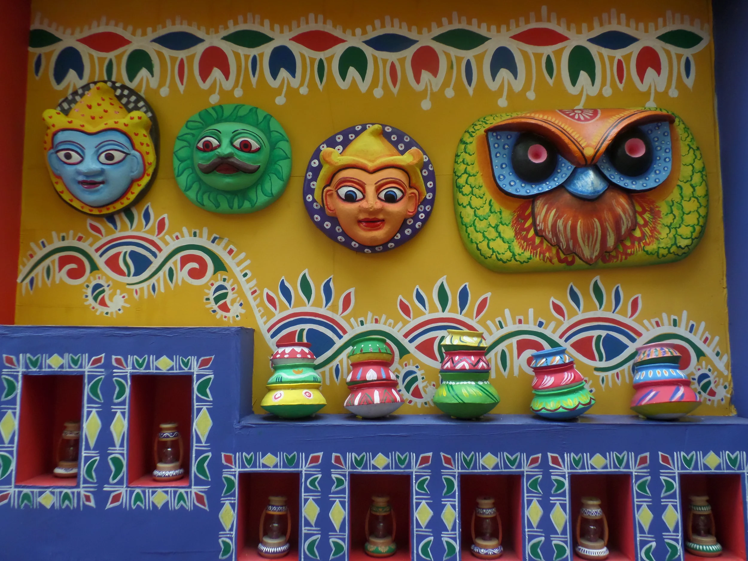  The side walls of the pandal decorated with colourful alpona and masks. 