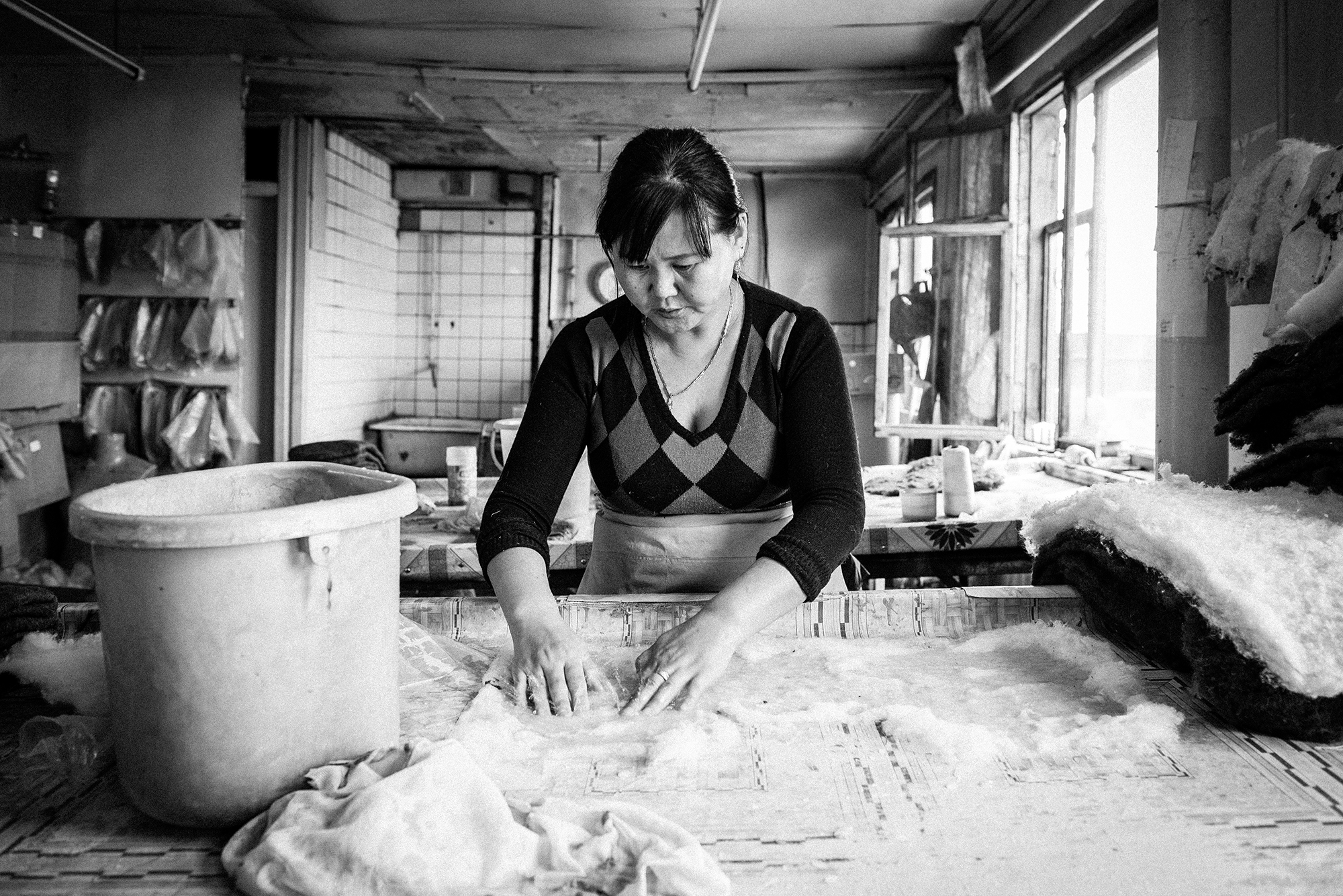 An Angel Felting worker starts the felting process by rubbing water and soap onto the woollen sheets, later shaping each one roughly around a slipper-shaped mould.
