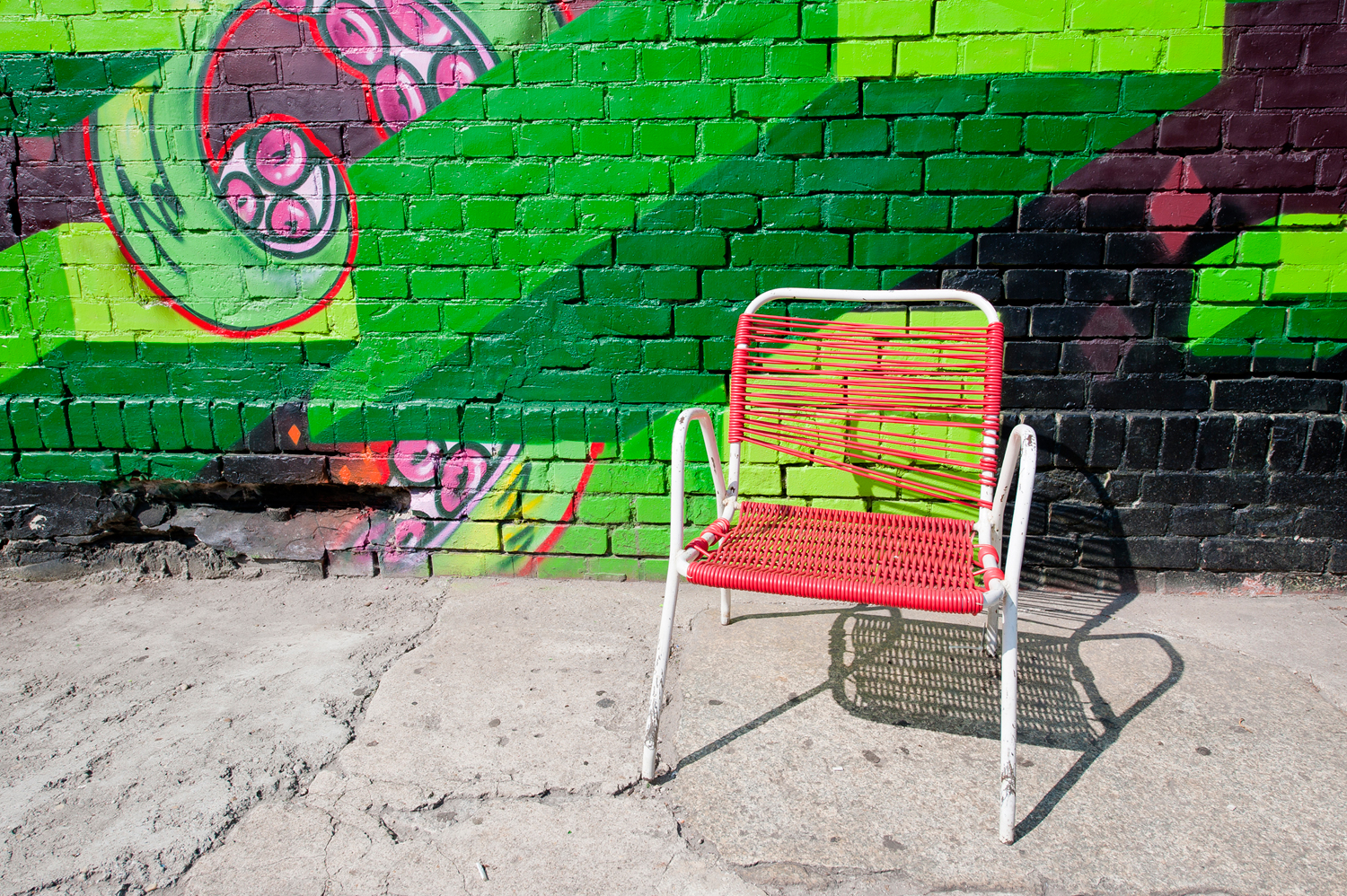 Chair with a perfect complimentary colour against a bright-green graffiti wall at the alternative RAW cultural complex in Berlin.