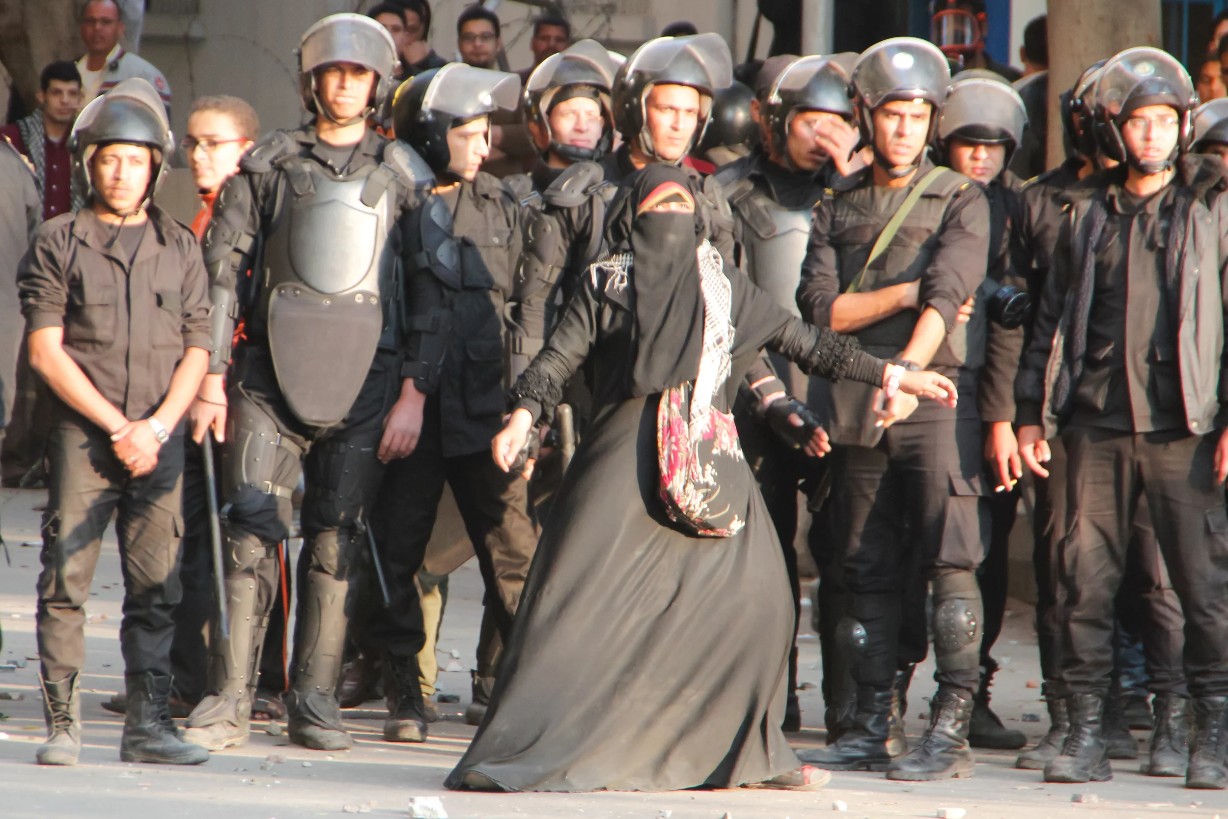 Cairo, Al Qahirah, Egypt -- A woman tries to protect CSF forces from protesters throwing bricks. The photographer claims they said lied in their promise to release her brother. March 5, 2013 (Photo: Bora S. Kamel | Flickr)
