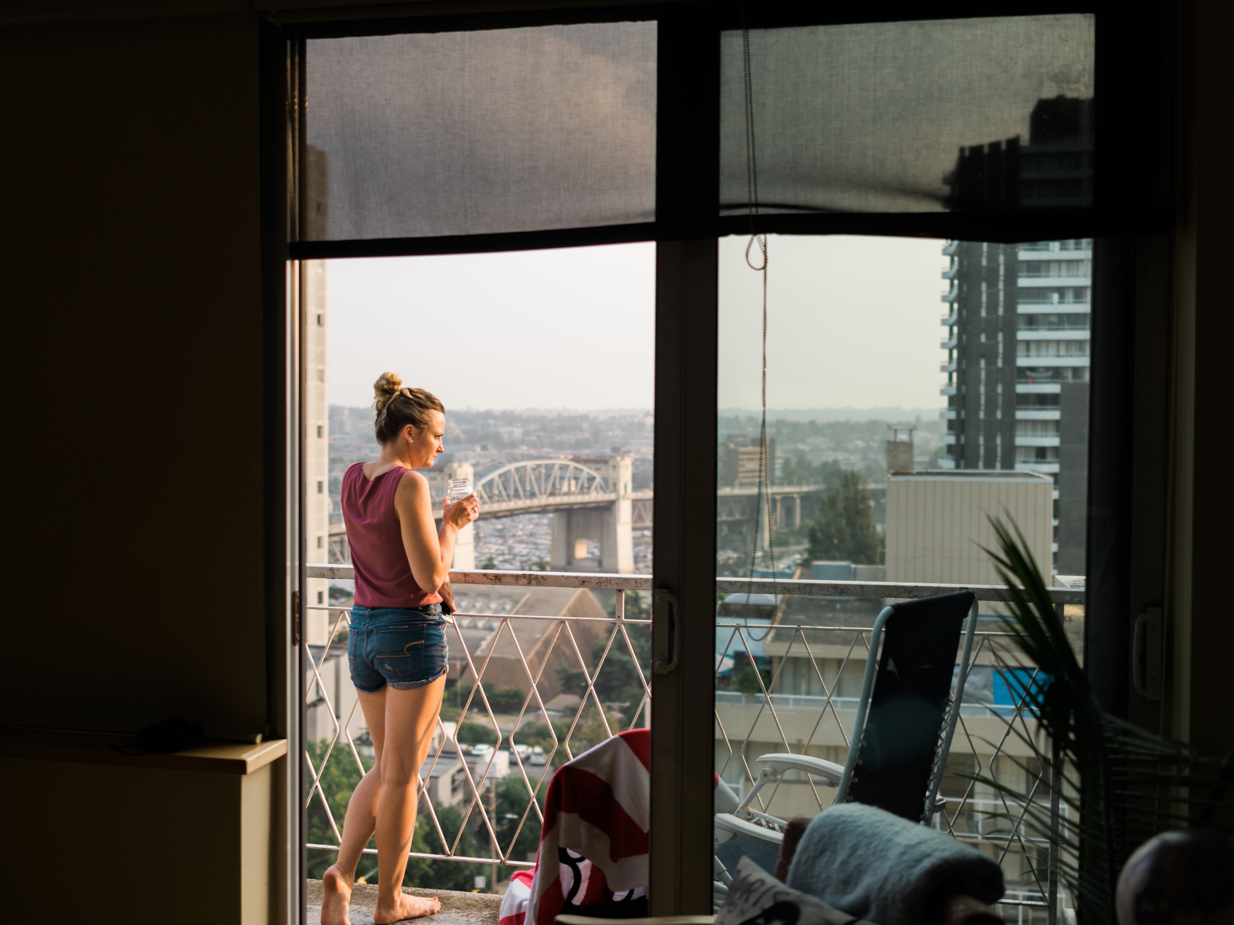  This is environmental portrait around golden hour in Vancouver. I was using the balcony door as a frame within a frame. One trick I learned is to temporarily crop in tight on the bright areas of the photo and adjust the photo until the histogram sho