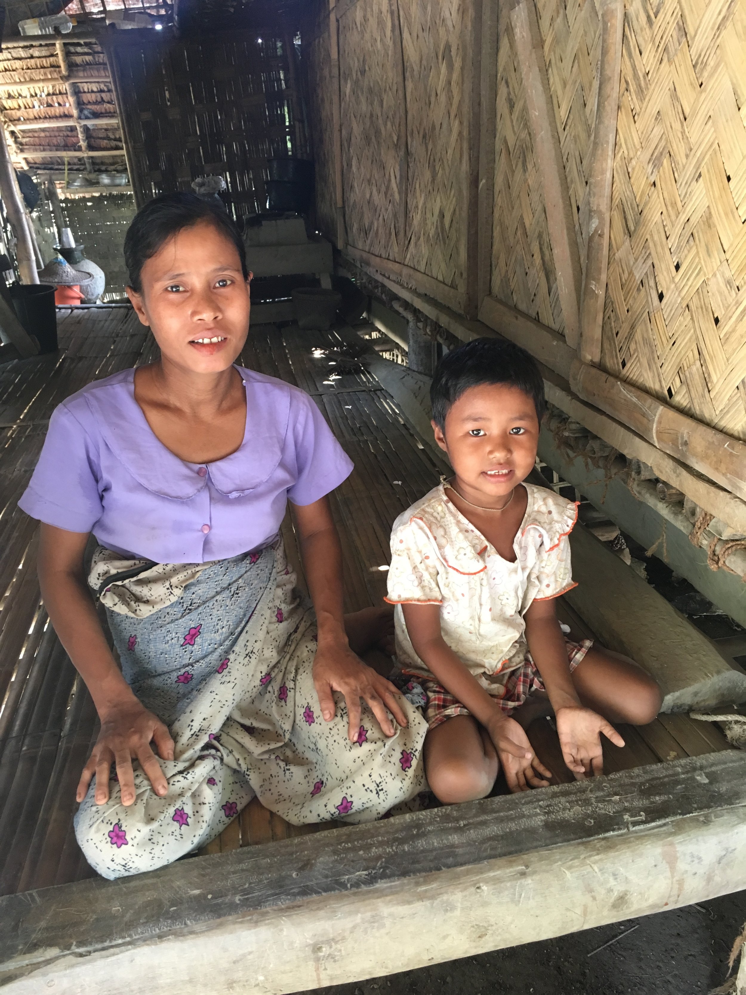 “We are casual workers, and after the floods, there is less work for us.” In a remote village in the Mimbya Township of Rakhine State, the 2015 floods swept away Zaw’s* family’s small bamboo house, their few belongings, and all of their animals (six chickens and a pig). Since the 2015 floods damaged nearby paddy fields, Zaw and her husband, both casual workers, now face increased competition for whatever work opportunities are available, and their daily wages are half of what they were before the floods. Five months pregnant and the mother of two, Zaw sits with her youngest daughter (pictured) in their reconstructed basic bamboo shelter and explains that, due to the family’s now much-reduced weekly income, Zaw is no longer able to afford the fee to send her youngest child, Yu* (pictured), to school.