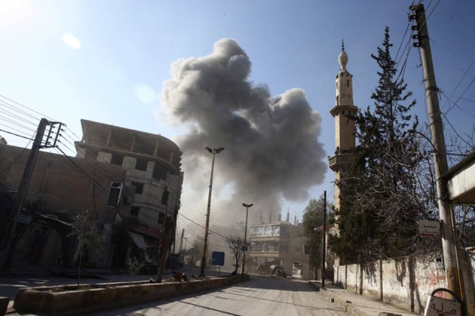Photo Credit: Reuters - Smoke rises from the rebel held besieged town of Hamouriyeh, eastern Ghouta, near Damascus, Syria, February 21, 2018.