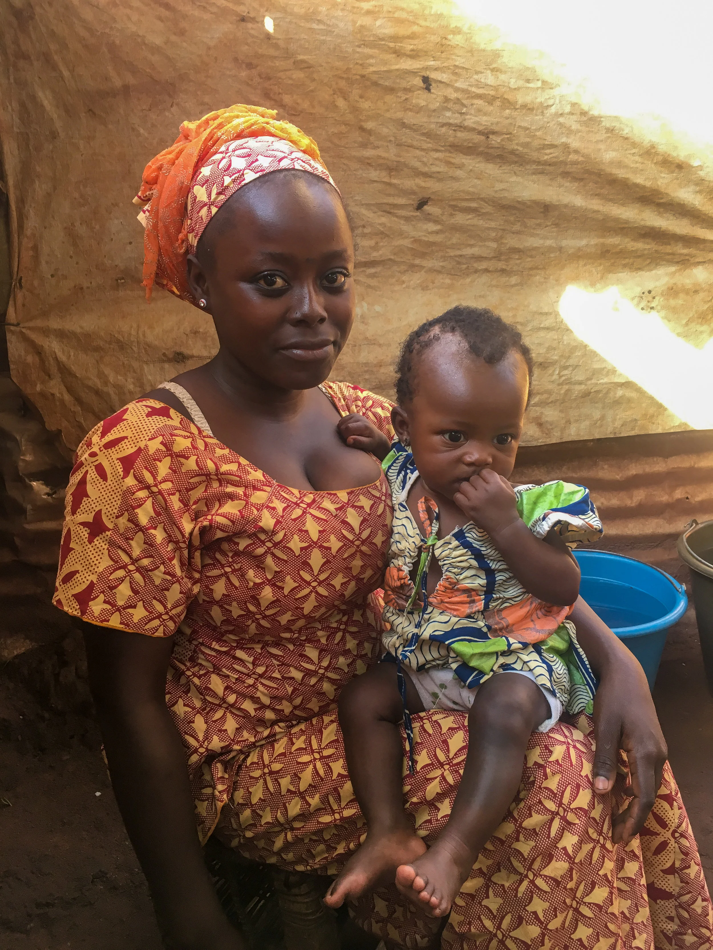 A young woman holds her child in the Bangassou IDP camp where she gave birth. Photo by Refugees International.