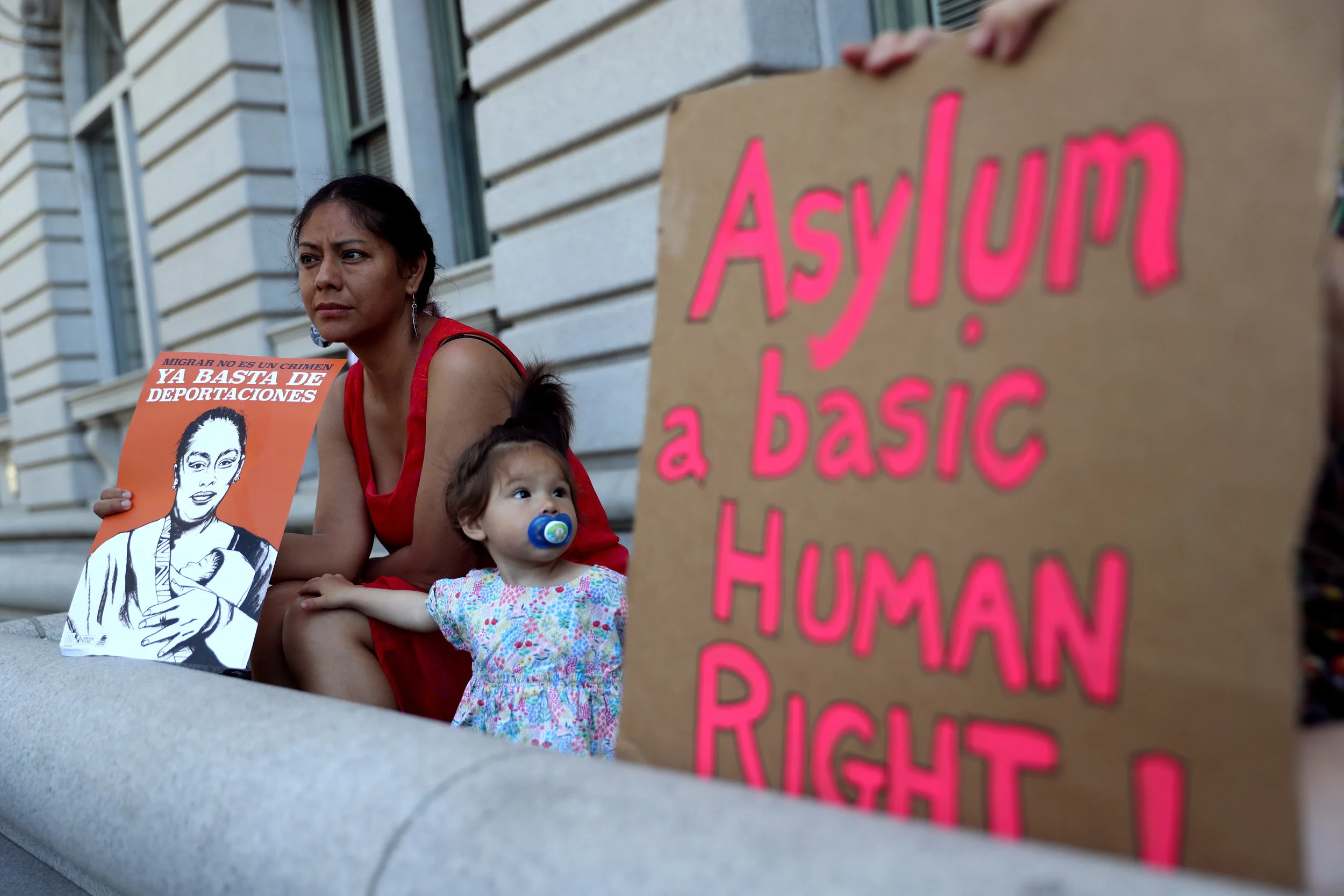 A protester holds a sign during a demonstration outside of the James R. Browning U.S. Courthouse in support of restoring protections for asylum seekers. Photo Credit: Justin Sullivan/Getty Images.