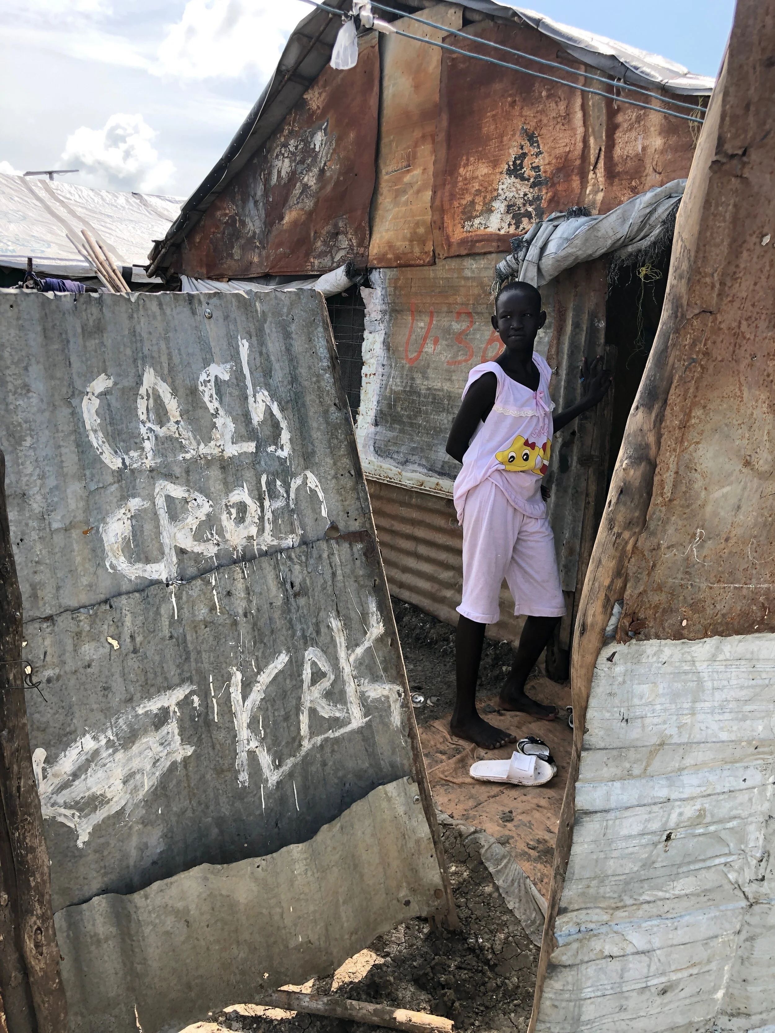 The Refugees International team spent days interviewing people in the POC, and met dozens of men, women, and children. Here a teenage girl waits outside her neighbor’s house. Adolescent girls often face threats of sexual violence and early marriage in South Sudan. Aid agencies and NGOs are trying to address these issues through various programs.