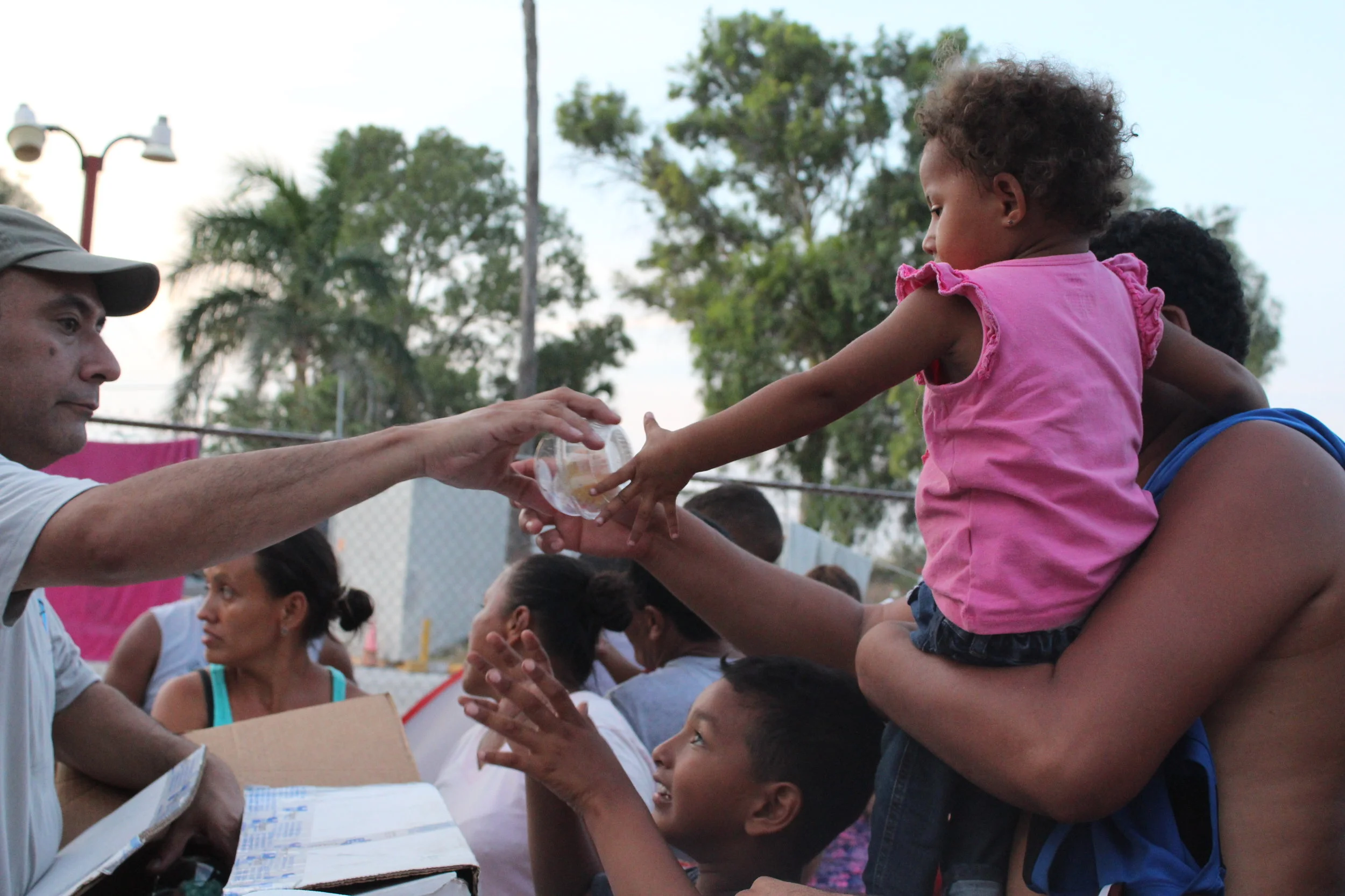 American volunteers provide food to returned asylum seekers.