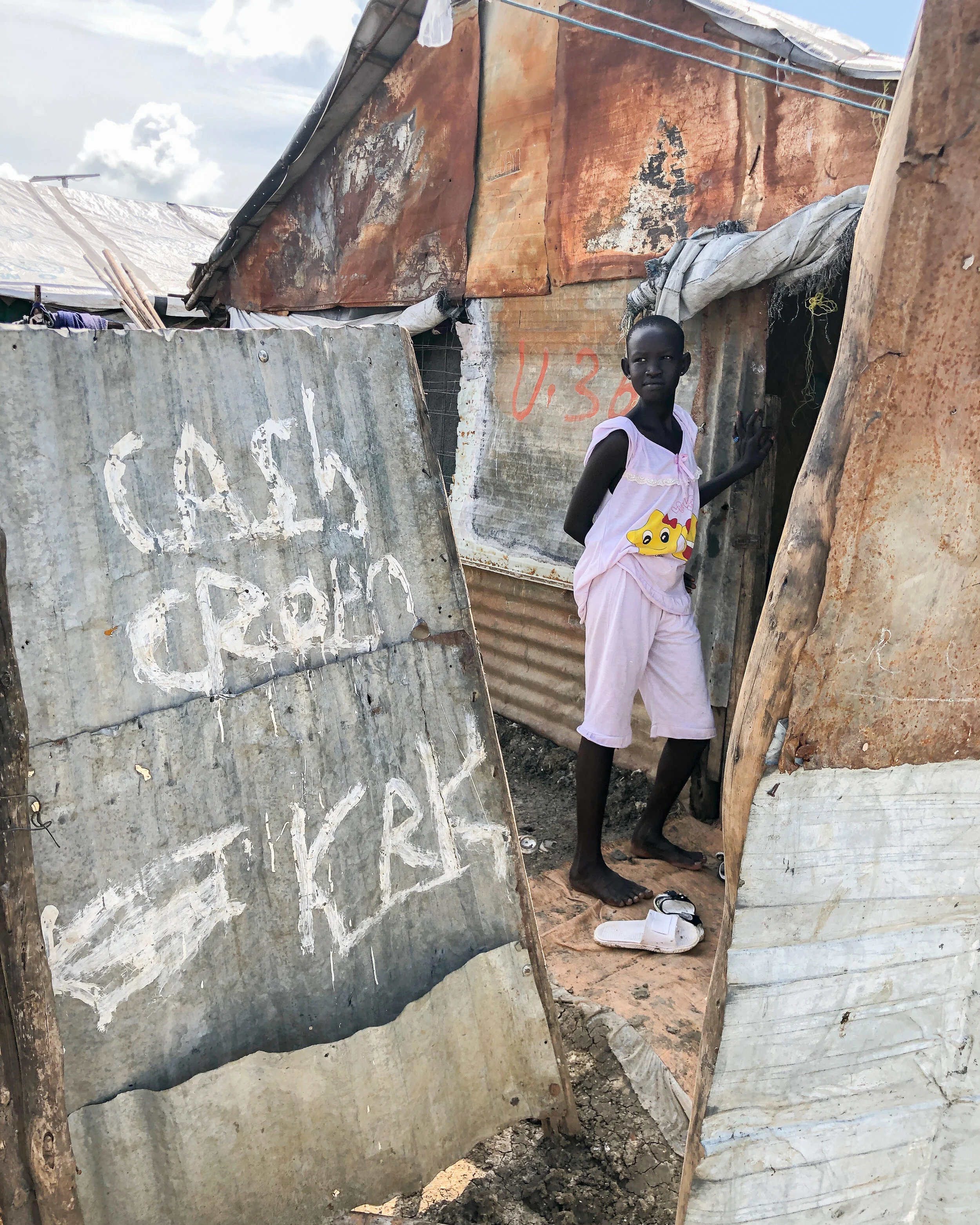 A teenage girl outside her home in the Malakal PoC. Photo Credit: Devon Cone/Refugees International.