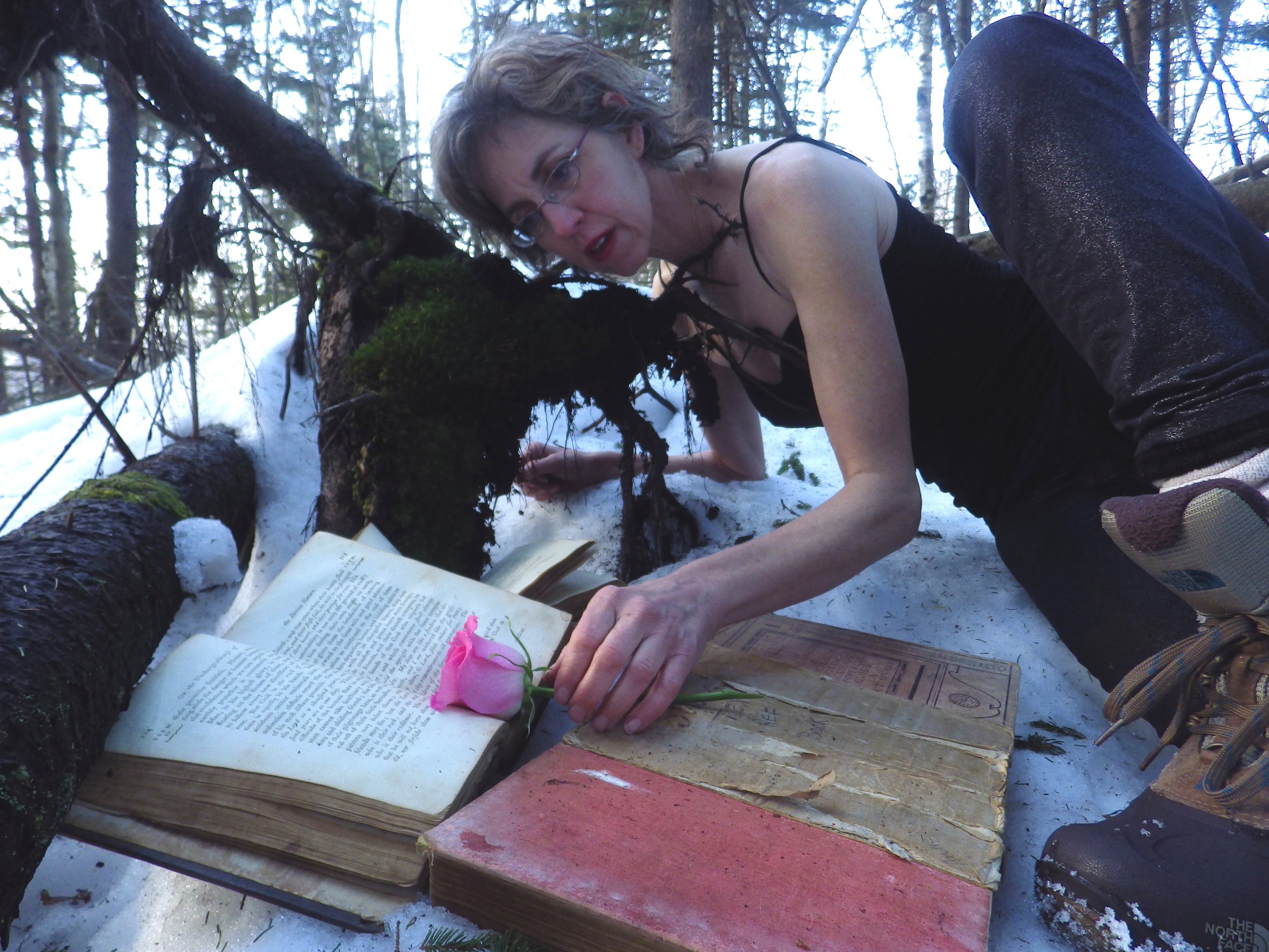 Kate Tarlow Morgan, “dancing with books,” poses in her Invisible Stories Winter.