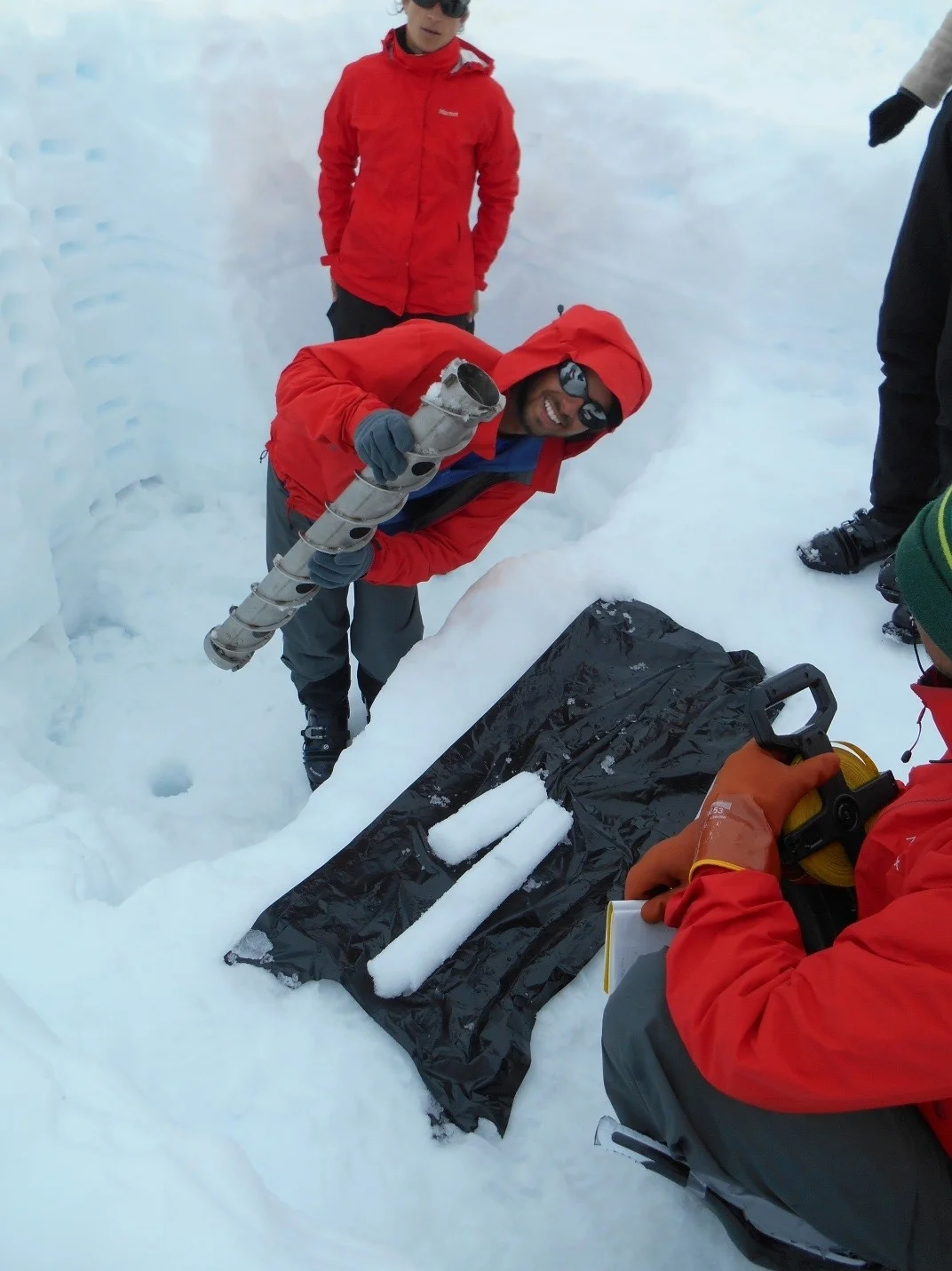 Austin C. with ice core samples from snow pit on the Taku Glacier. (photo credit Jutta Hopkins-LeCheminant)