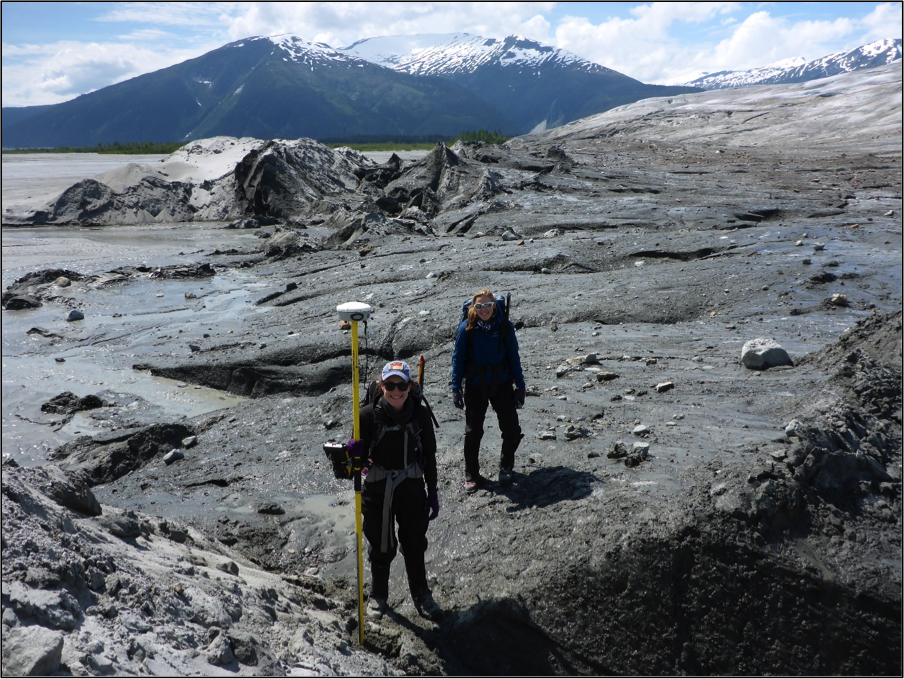 Olivia Truax and Cézy Semnacher taking a GPS point at the boundary between ice and sediment at the terminus of the Taku Glacier.