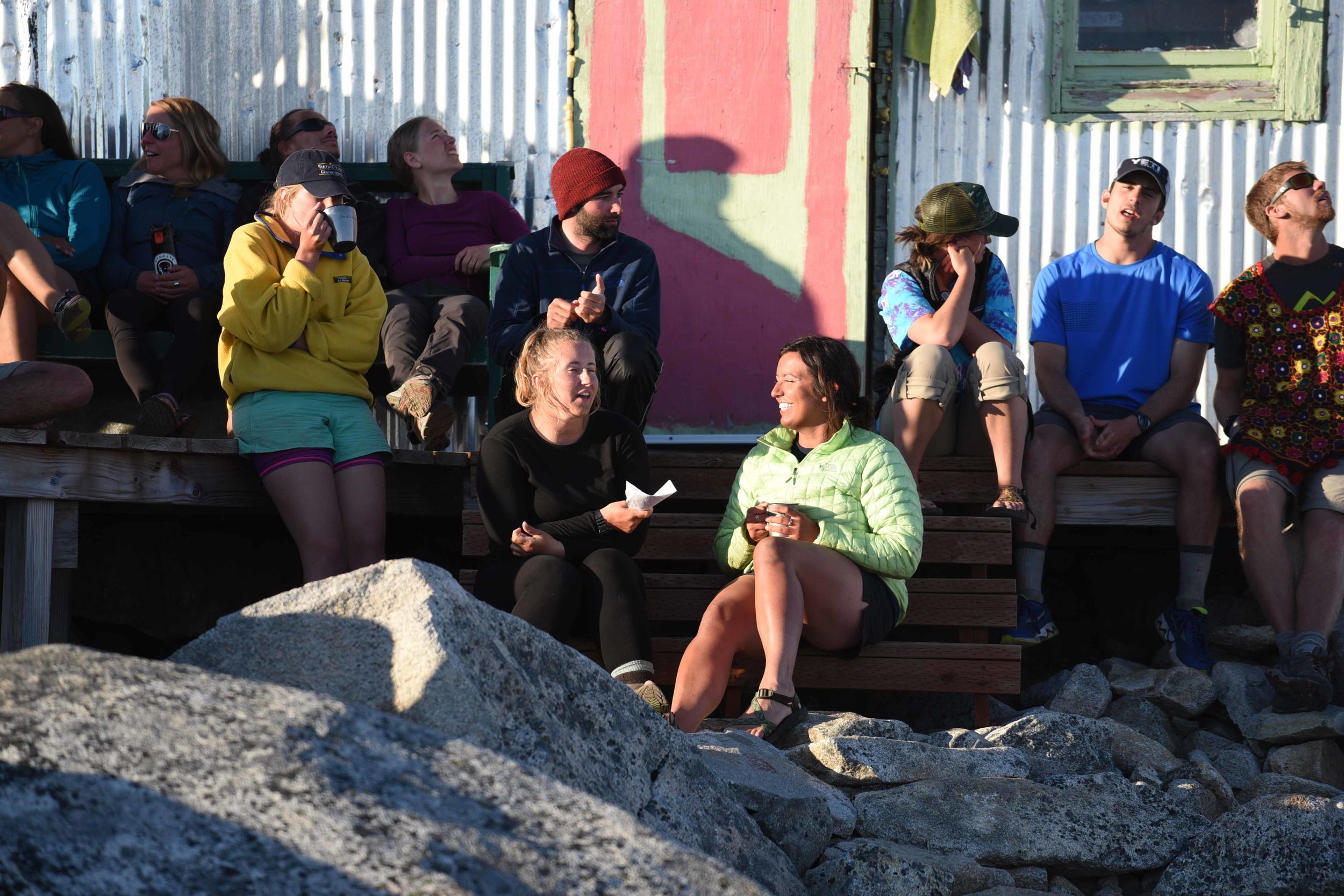The author, in yellow with cup in hand, sharing stories in camp with fellow JIRPers. Photo courtesy of PBJ Photography.