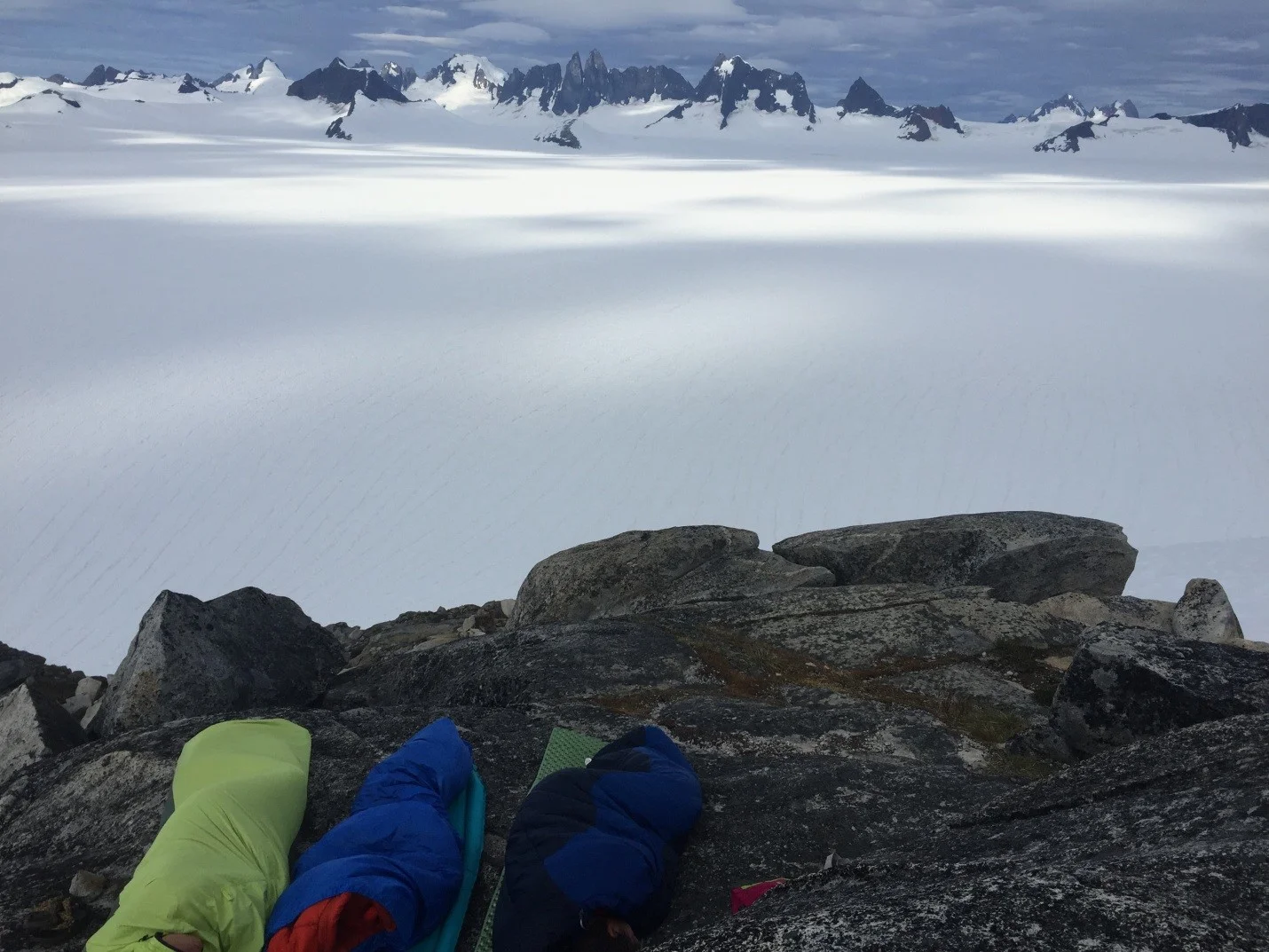 My first night in Camp 10, sleeping in the best bivy spot. The view is looking across the Taku Glacier at the Taku Towers (they can be spotted right in the middle of the peaks shown). This night included both an early morning sprinkle and a glaring sun wake-up. Photo by Auri Clark.