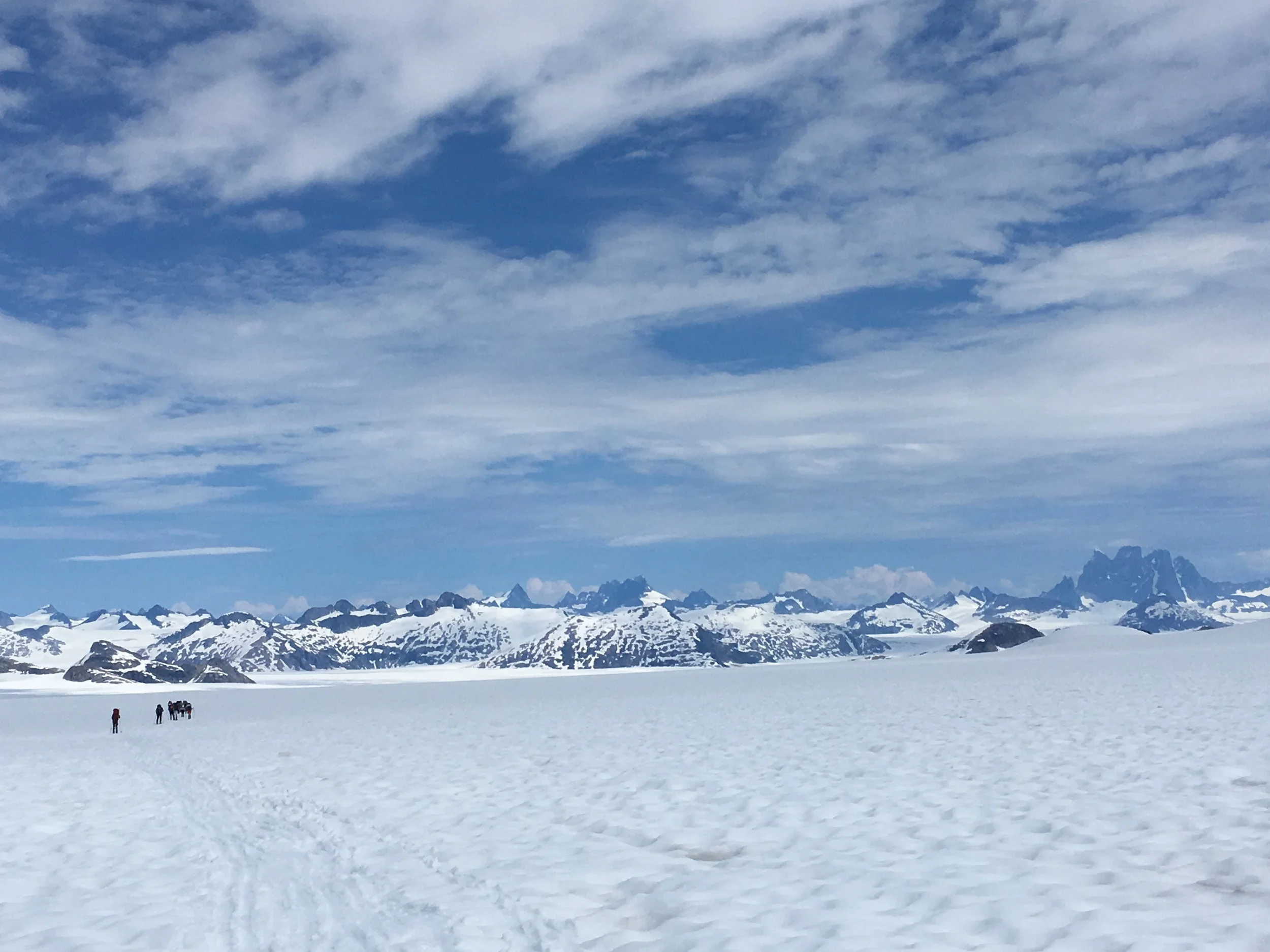 A trail party skis towards Camp 10, which is visible in the distance, but many hours away. Photo by Evan Koncewicz.