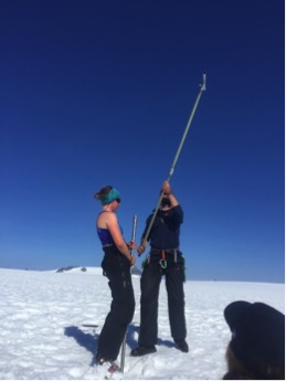 Caption: Kit Cunningham and Chris Miele adding flights to the drill (partly lowered in the hole). Photo credit: Sarah Fortner