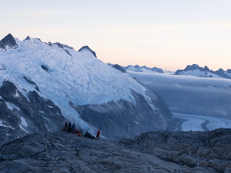 Faculty member Billy Armstrong (right, red jacket) holds an evening lecture on ice flow dynamics above the Gilkey Glacier.