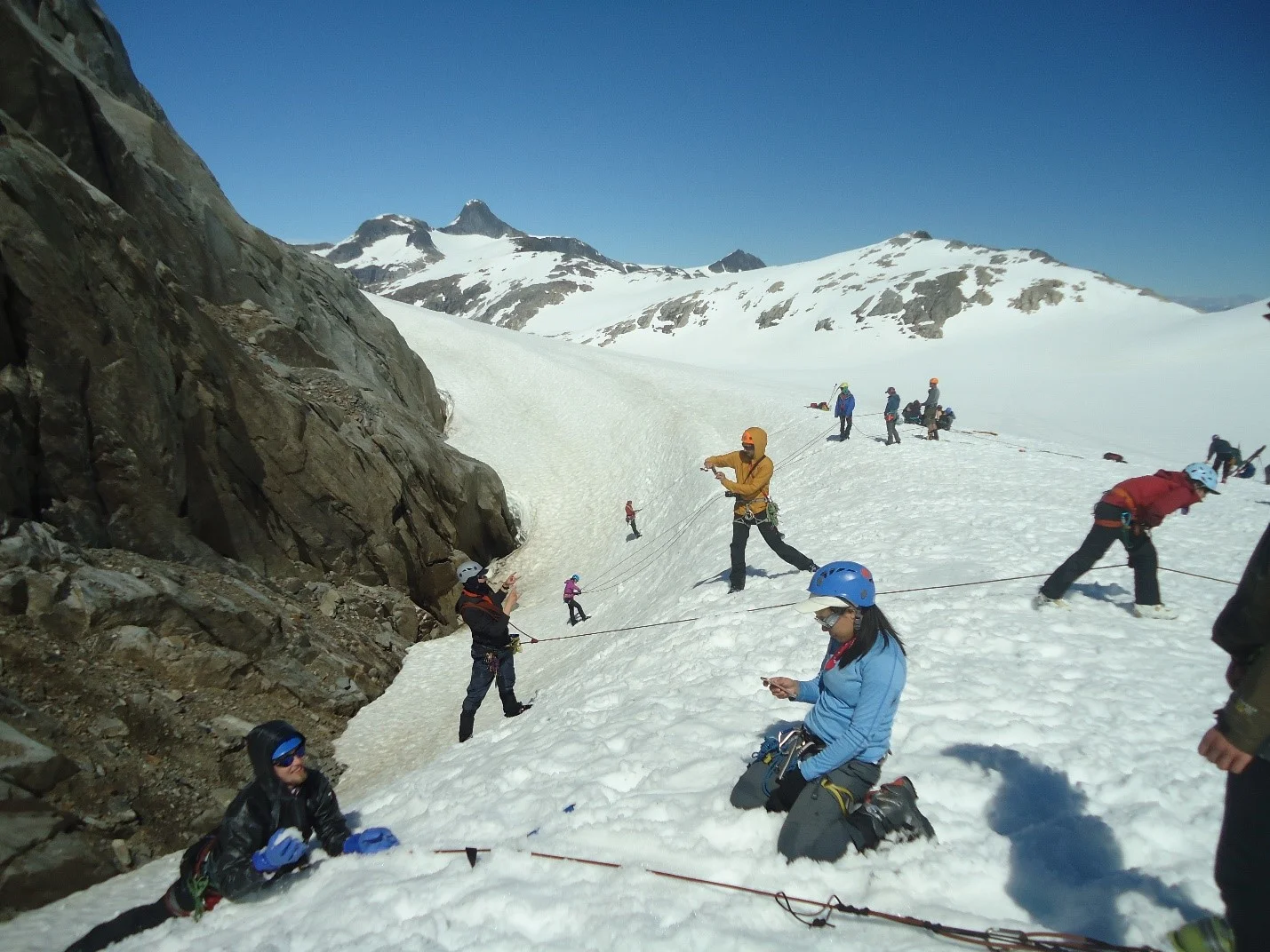 Building on roping up, we’ve also been practicing building anchor and pulley systems to actually be able to pull people out of a crevasse. Snow anchors allow us to take the weight of the fallen person off of ourselves and the pulley systems give us mechanical advantage to pull them up more easily (it was an added training bonus that it stopped raining and the sun shined for the first time in 6 days!). Photo credit: Kelcy Huston.