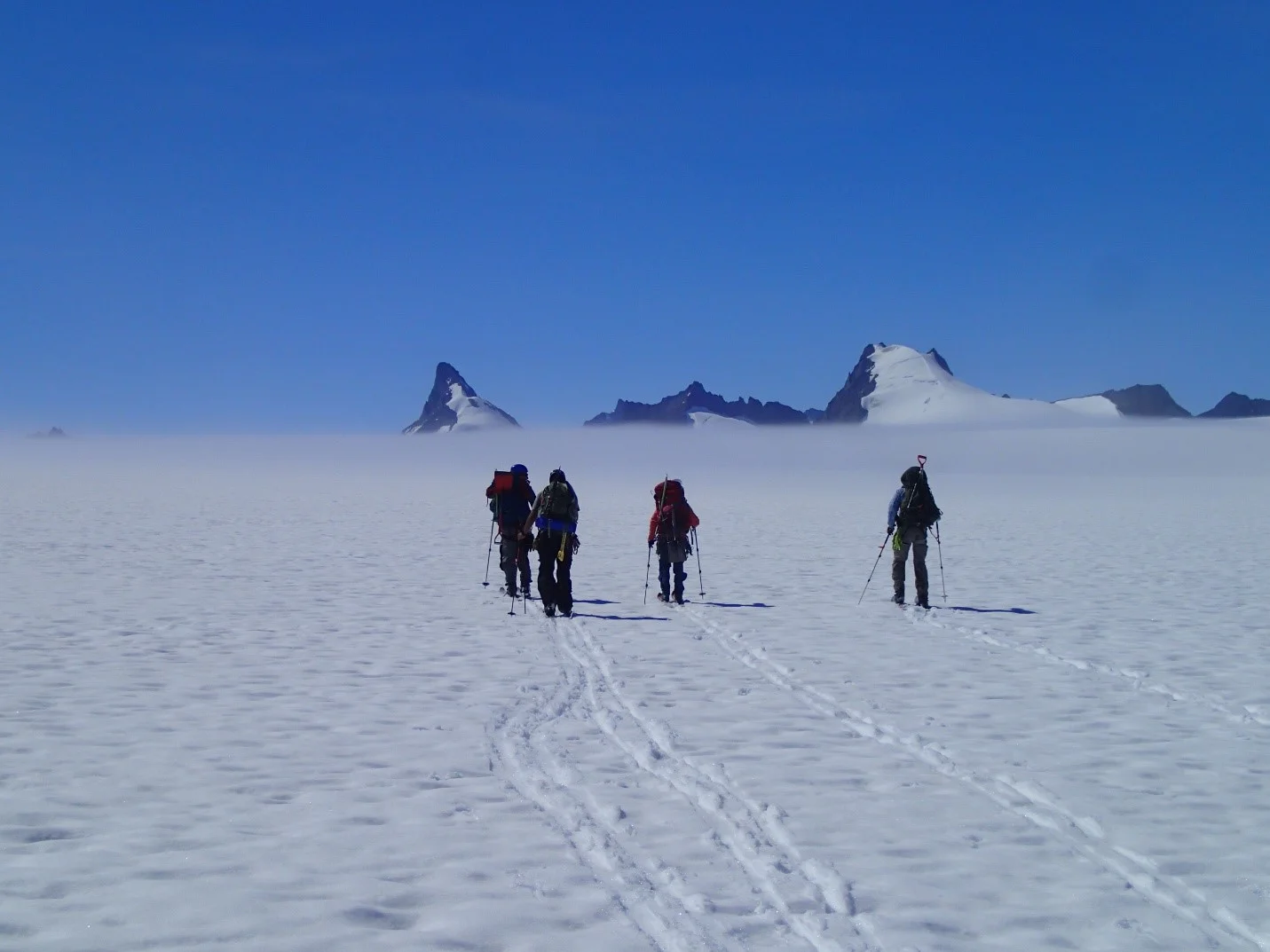 Part of the mass balance group skiing to their pit located behind Emperor Peak. Photo credit: Julian Cross.
